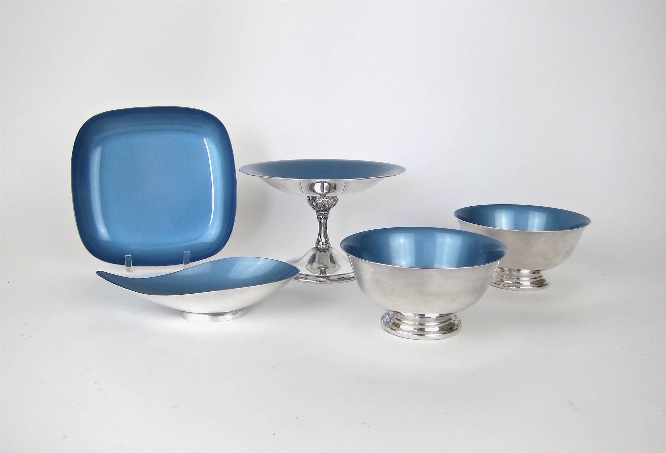 An exquisite collection of Mid-Century Modern silver plate designed by metal smith John Prip (1922-2009) and introduced by Reed and Barton as the "Color-Clad" line in 1961. Each vintage item is decorated with a gorgeous, icy blue enameled