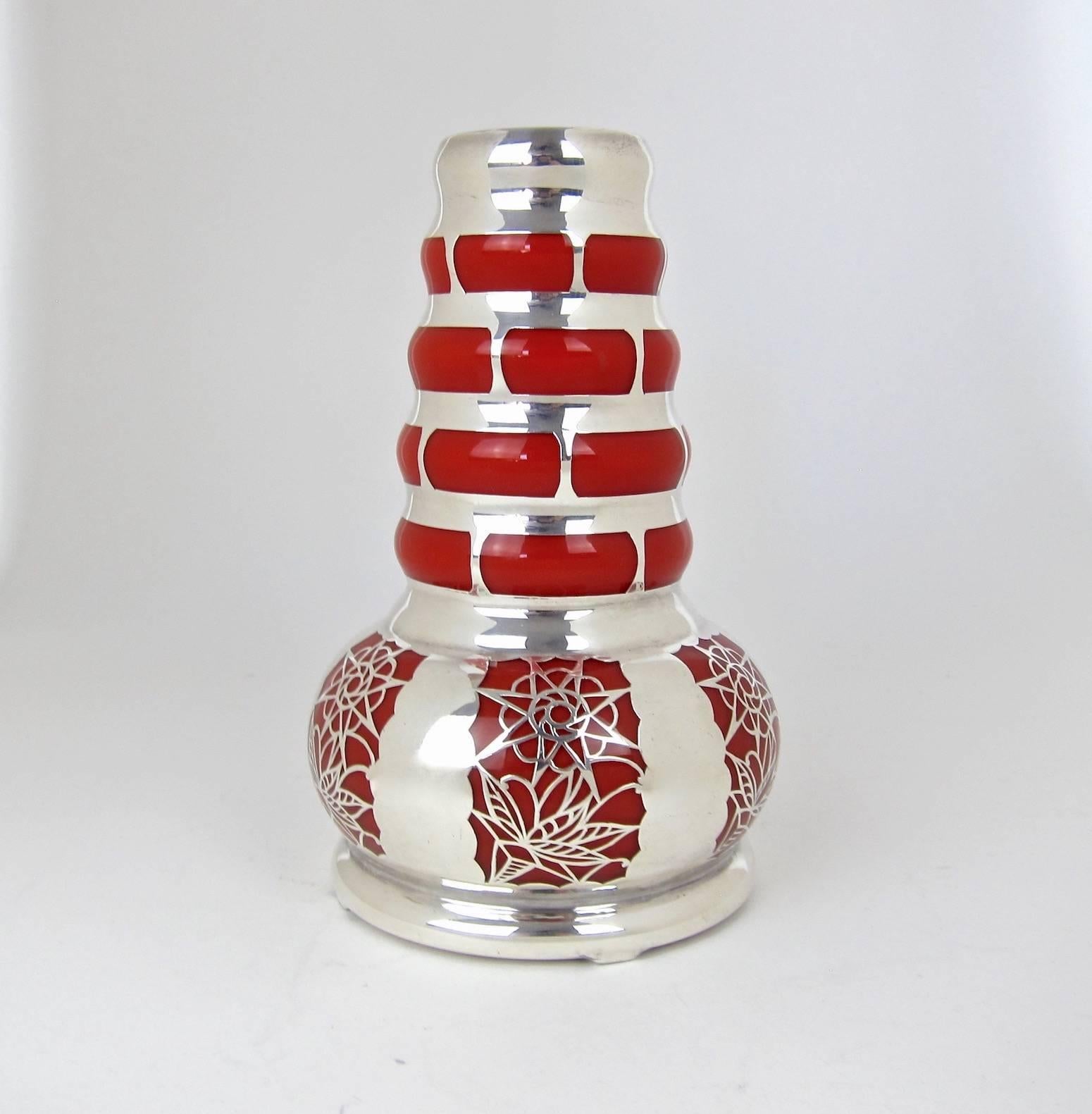 A vintage continental vase of opaque orange glass encased within a sophisticated pure silver overlay.

The vintage glass vessel is likely of Czech / Bohemian origin with the ornamental silver overlay designed and completed during the 1950s in