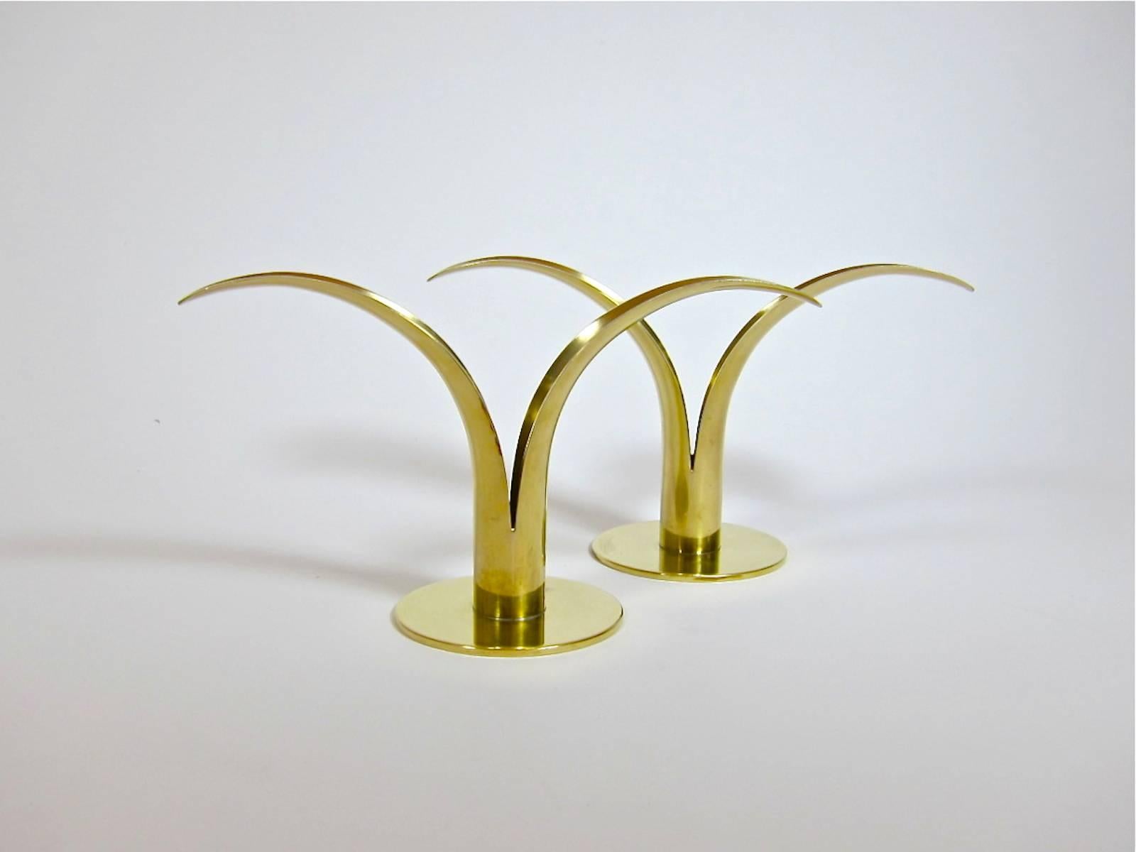 A stylish pair of modernist Liljan (Lily) candlesticks in sleek, golden brass, designed by Ivar Åhlenius-Björk for Ystad Metall of Sweden. Marked Ystad-Metall/made in Sweden on each base with designer's initials 