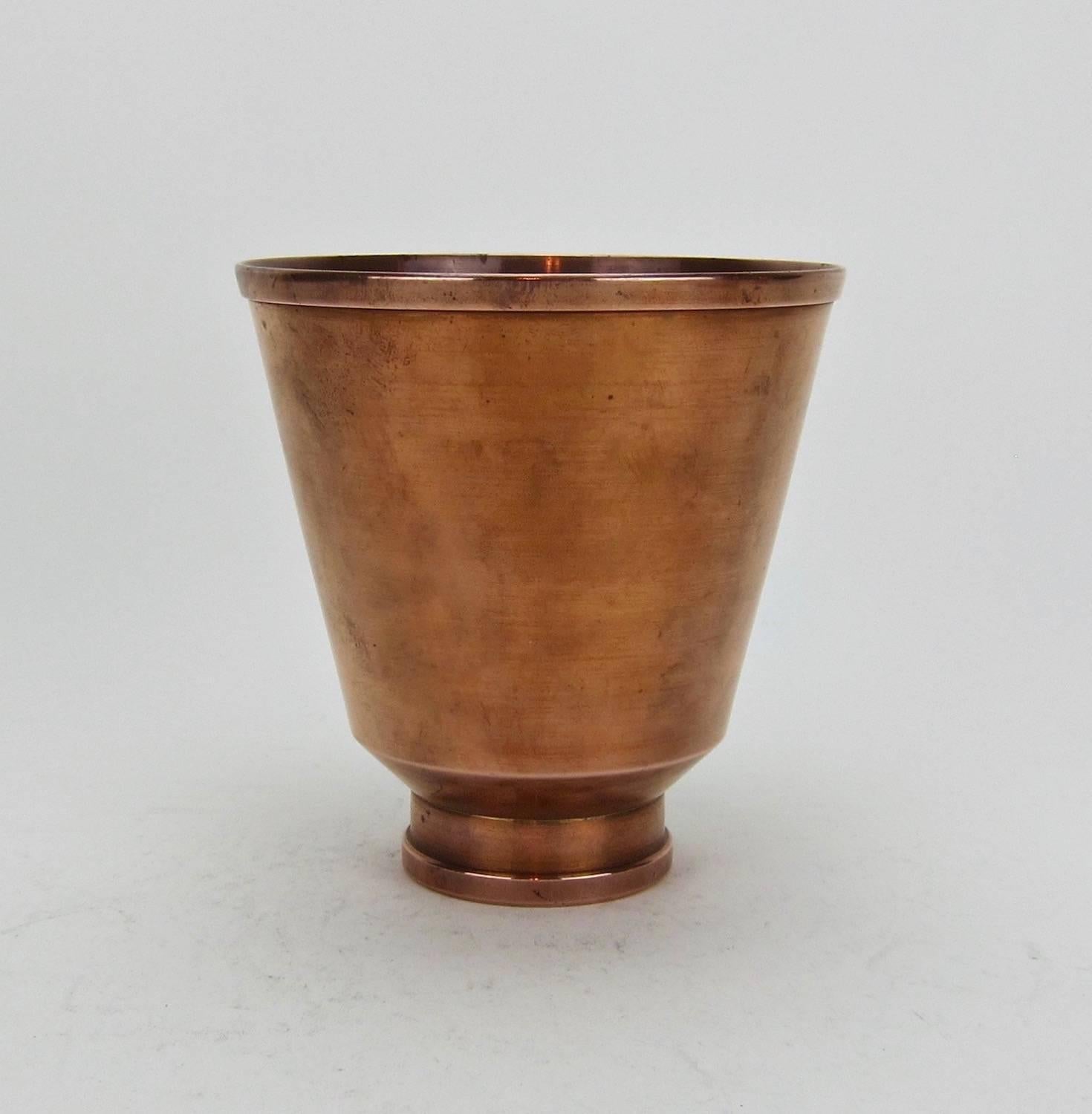 An antique Arts and Crafts era flaring vase in spun copper resting on a ring foot by Marie Zimmermann (1879-1972), a noted American metalsmith, jeweler and designer active during the opening decades of the 20th century. The vase comes from the
