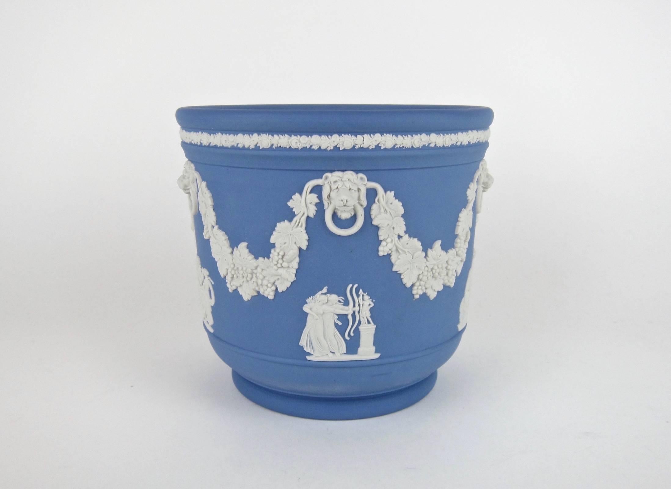 A vintage jardinière or cachepot from an important California collection of English Jasperware by Wedgwood. 

The pale blue solid jasper body is decorated in relief, beginning with an intricate floral border encircling the rim. Grapevine swag