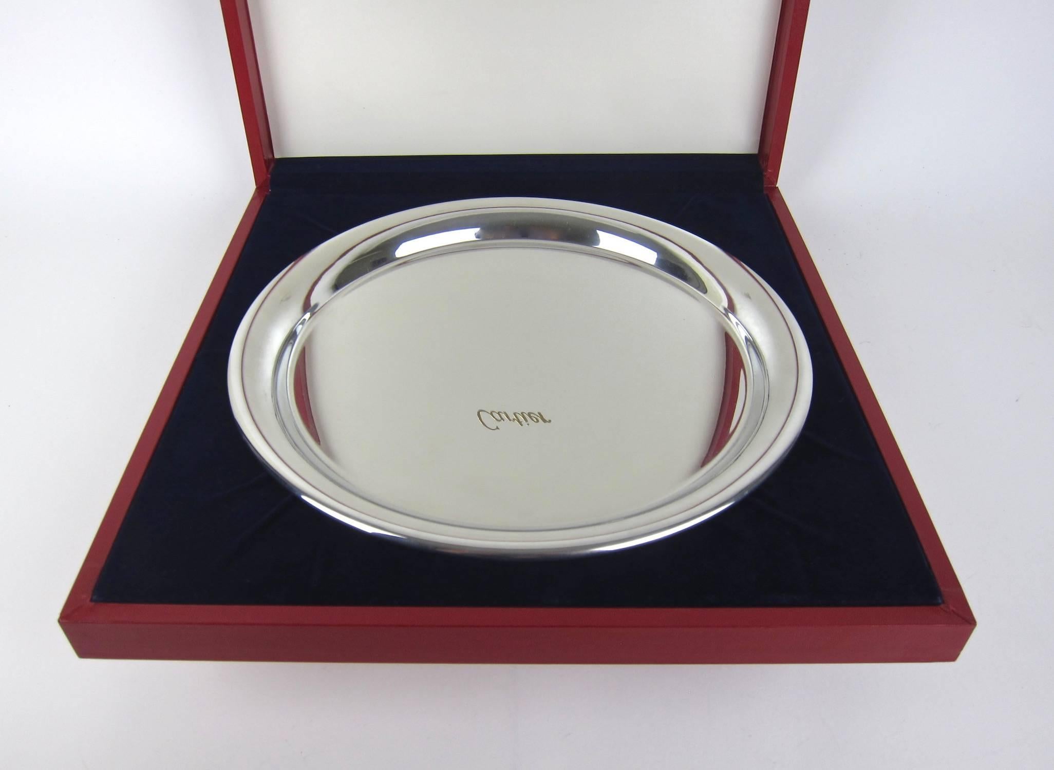An elegant vintage serving tray from Cartier, perfect for cocktails or cupcakes, in highly polished pewter. Made in France, circa 1977. The round tray has a modern, Minimalist design with a wire-wrapped rim, stamped 