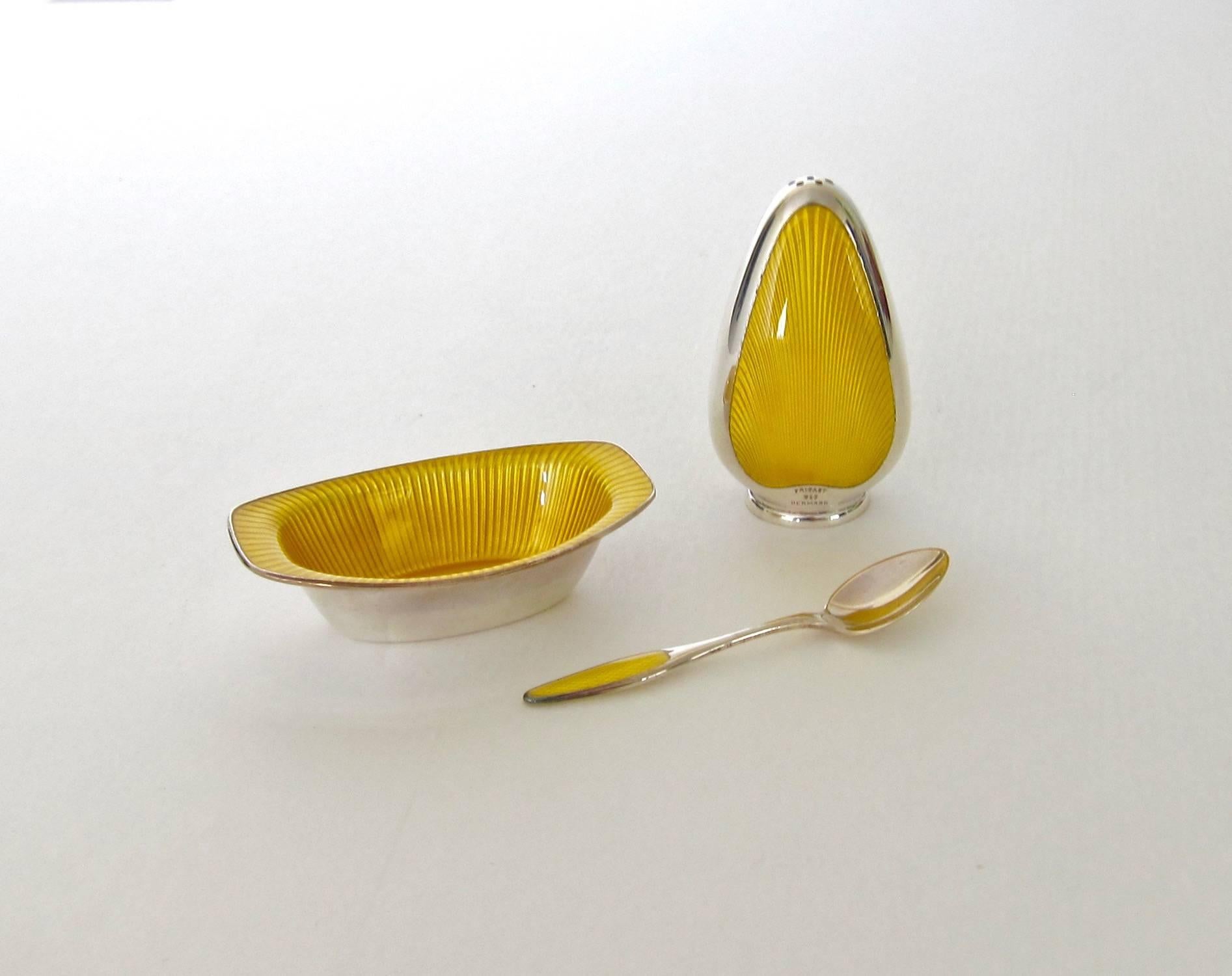 An open salt and pepper set in sterling silver skillfully decorated with contrasting golden yellow guilloche enameling from Frigast Silversmiths of Copenhagen, Denmark, active 1958-1976.

The boxed set consists of an open salt cellar with a