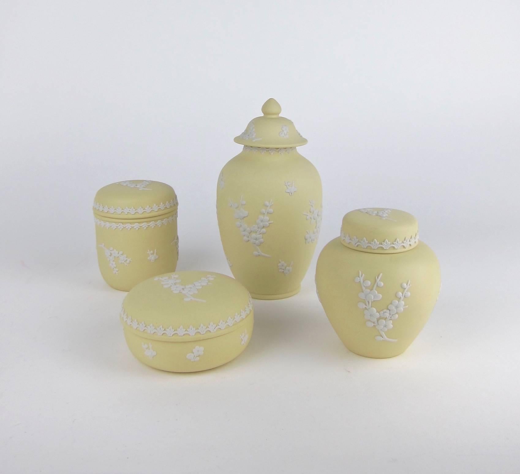 A vintage set of four English Wedgwood jasper ware covered vessels. The collection consists of a a temple jar, a ginger jar, a round box and a cylindrical box in solid Primrose Yellow Jasper, a color Wedgwood used between 1976 and 1982 for a small