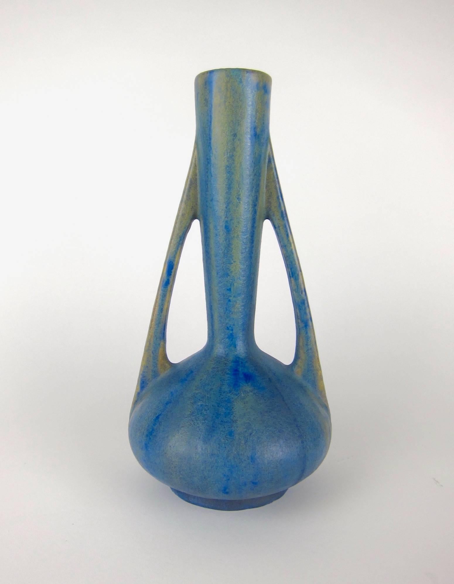 A superb turn of the 20th century Art Nouveau art pottery vase from Pierrefonds Pottery of France. The two-handled antique vessel dates circa 1905 and is decorated with a matte glaze of variegated shades of blue against a tan ground with blue