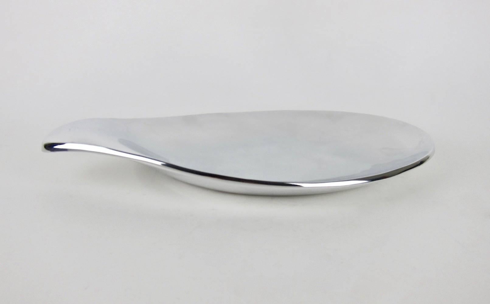 A 17-Inch long biomorphic silver metal platter designed by Eva Zeisel (1906–2011). Zeisel designed this sculptural serving piece for Nambe of New Mexico in 1999, basing the form on one of her mid-century designs for Hall China Company's Tomorrow’s