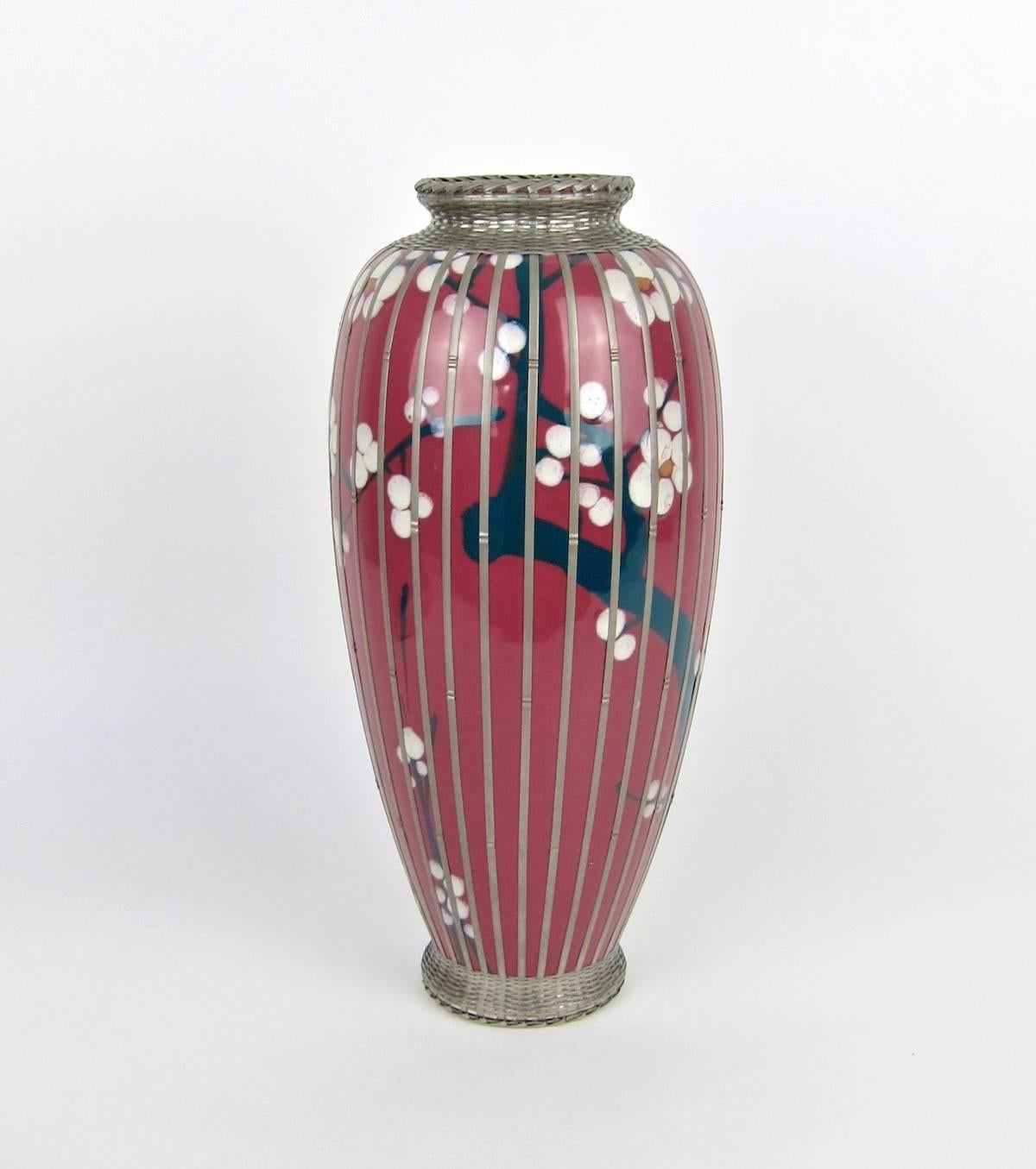 A large Japanese pottery vase, likely from an Awaji studio, dating to the early 20th century. The hand-thrown vessel is decorated with hand-painted Prunus pattern of cherry blossoms on dark green branches and stems against a rich, plum colored