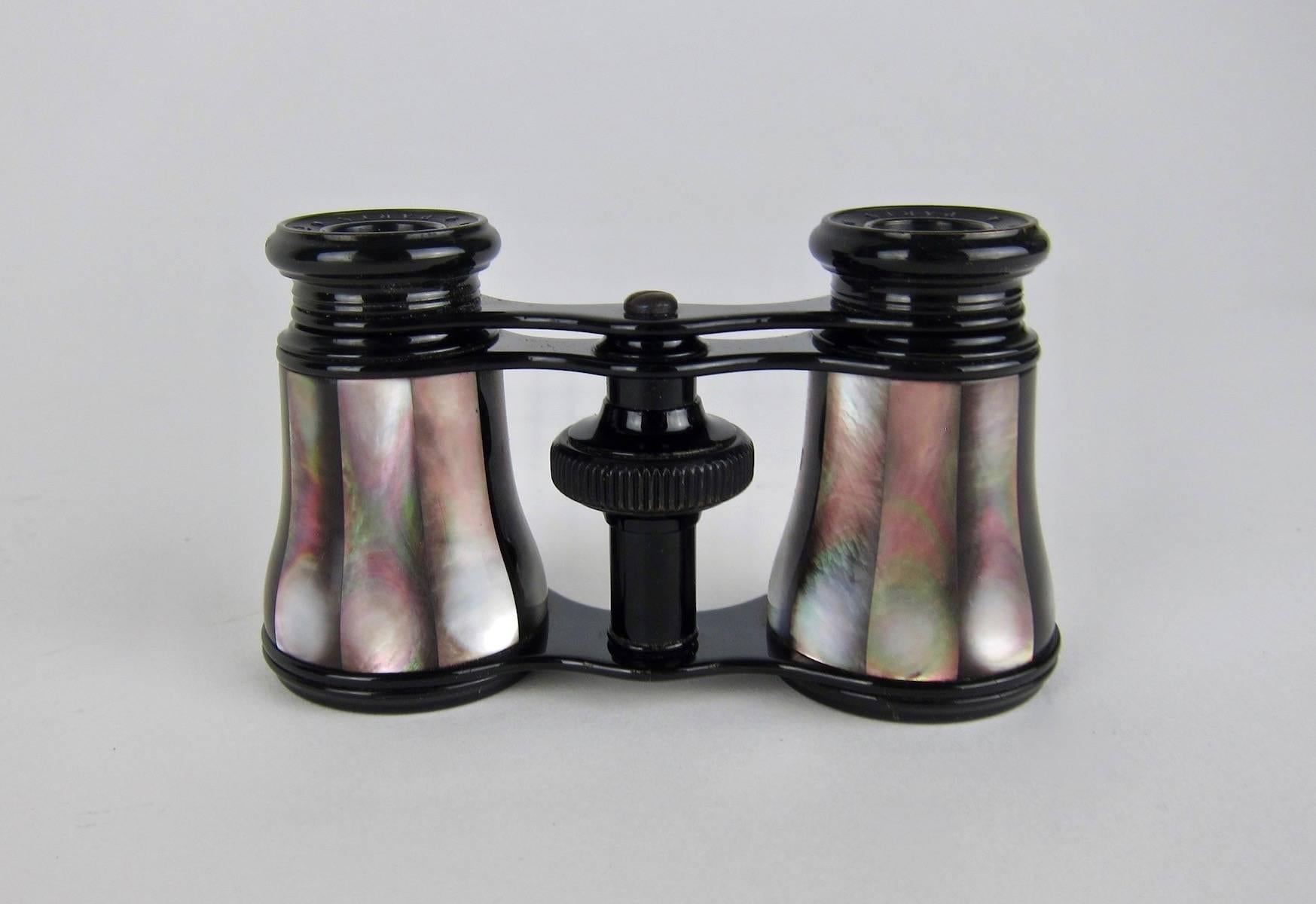 An elegant antique pair of French opera glasses or small binoculars with their original fitted leather case by LeMaire of Paris. The telescoping glasses have a black metal frame and the barrels are ornamented with dark iridescent abalone /