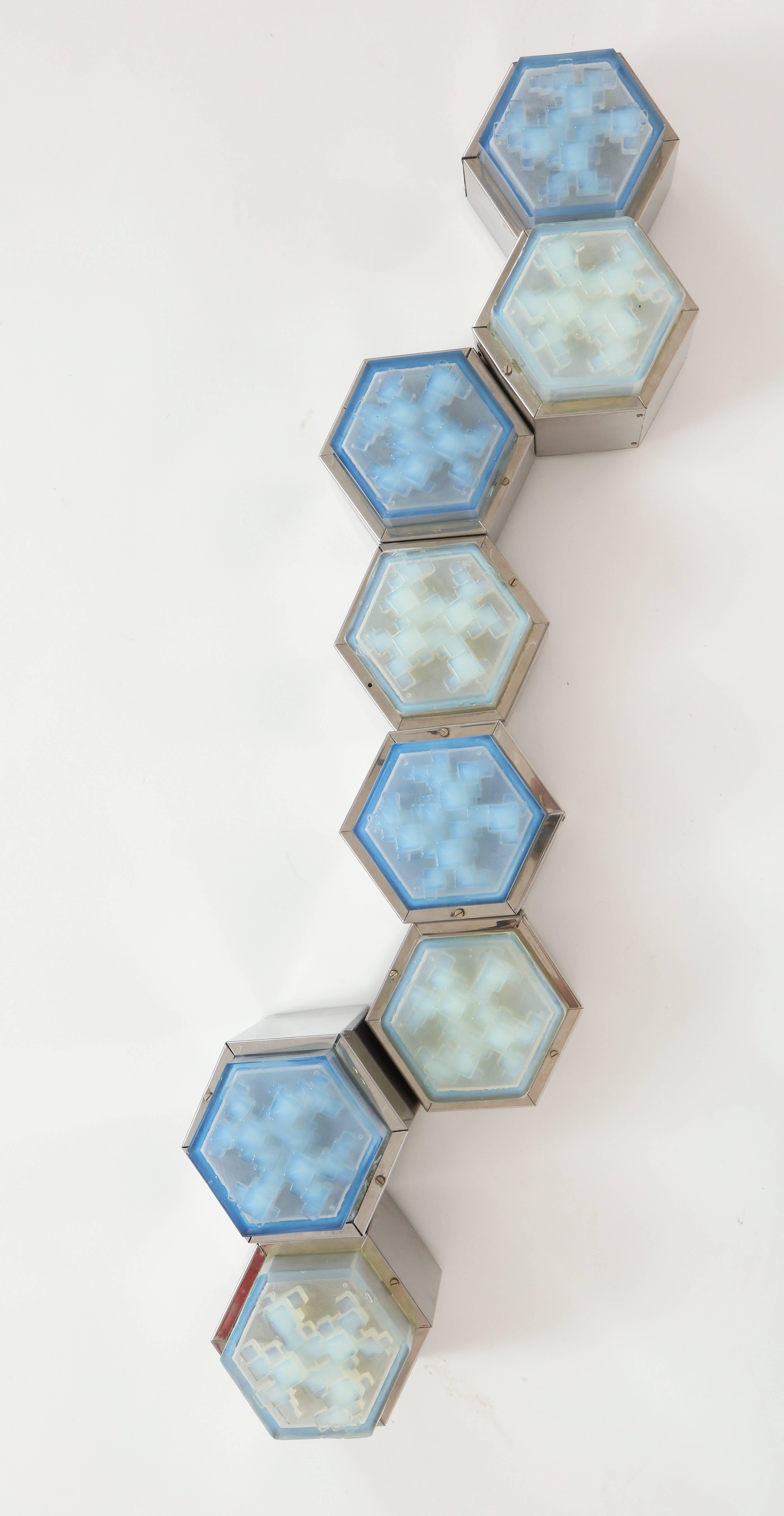Hexagonal Wall Light in Blue Chrome and Glass, style of Poliarte, 1960,1970 Italian

Lovely chrome and light blue wall sconce.
Eight pieces attached together.

3.5 inches Deep
12 inches Height
42 inches Wide