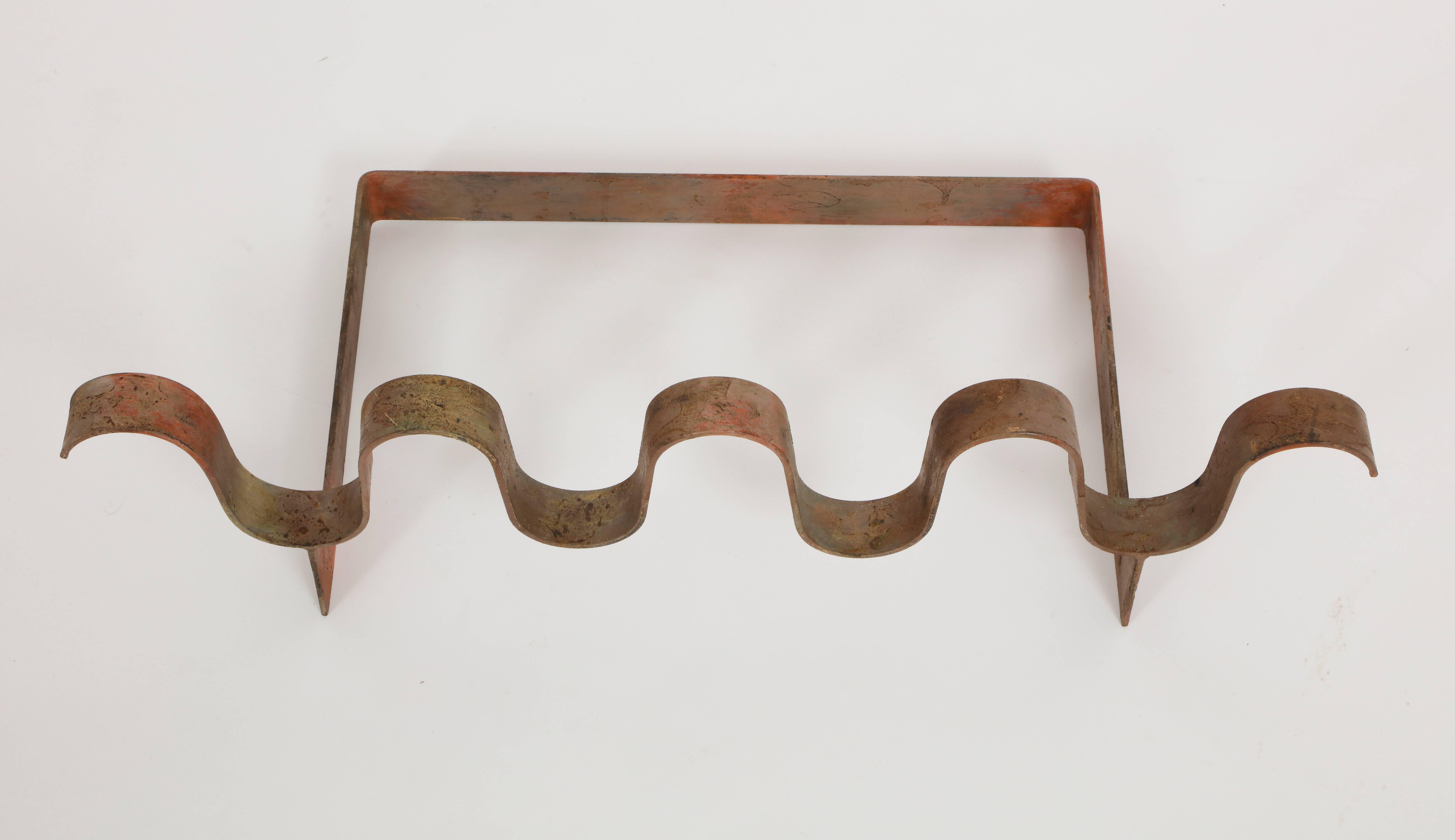 Architectural 1950s andiron France in the style of Jean Royere's ondulation lovely patina and shape. Made of wrought iron. Measures: 7.75 in. (20 cm) H x 27.5 in. (70 cm) W x 14.5 in. (37 cm) D.
