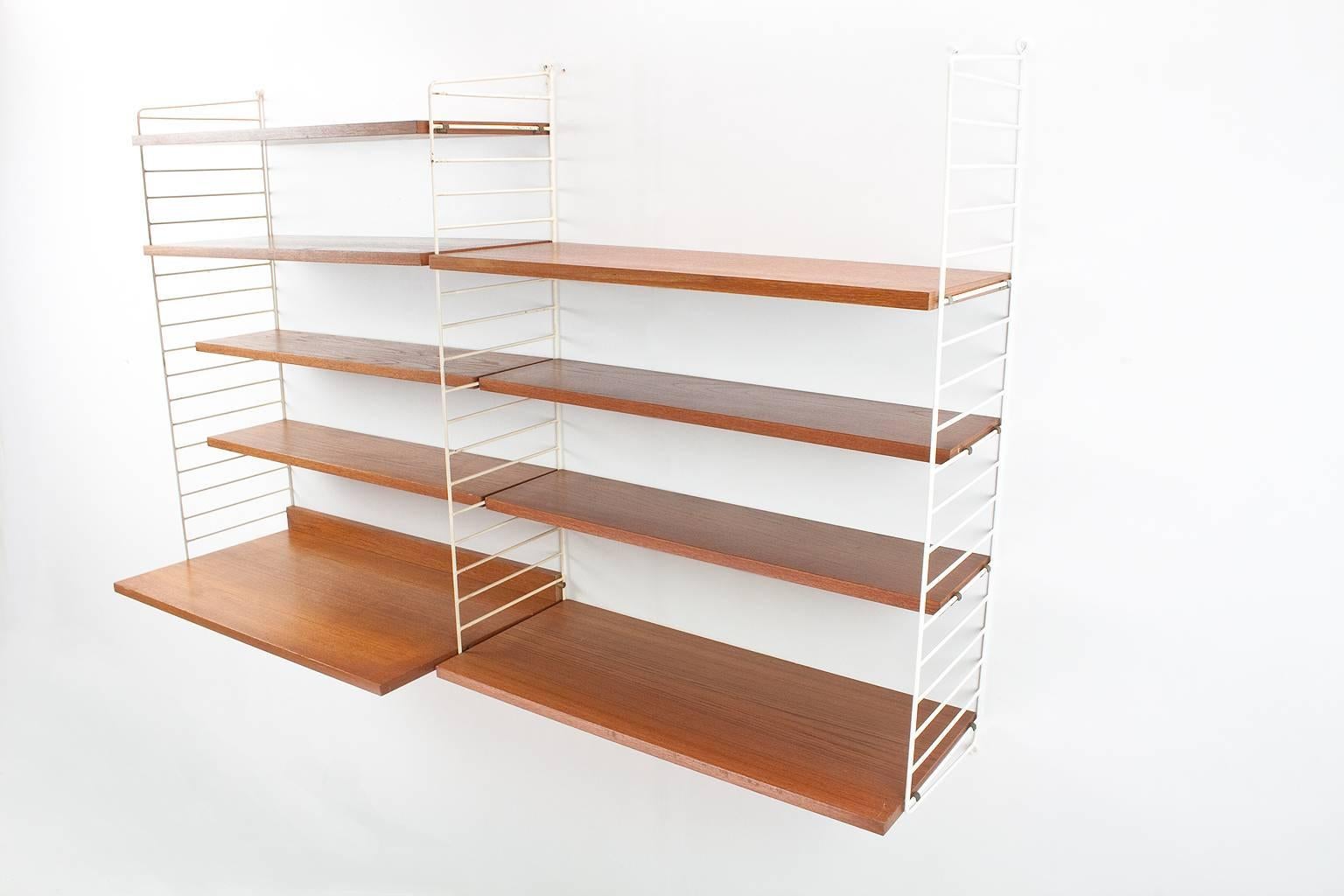 This 1960s teak (veneer) Swedish modular wall system by Nils (Nisse) strinning is in original and great condition. The elements can be placed in different heights on the brackets. Only little patina on the shelves conforming age; and as shown on