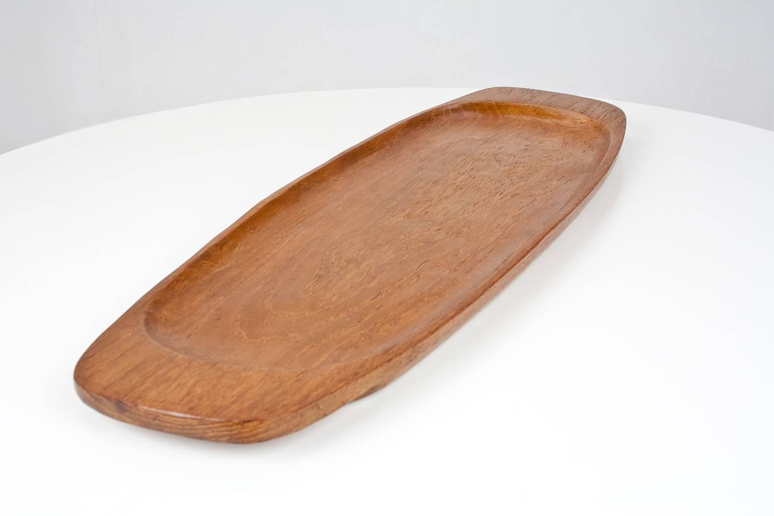 Mid-Century Modern large (61.5cm) Danish hand sculptured teak platter or tray. Beautiful table or desk accessory in excellent condition. Originated from the 1960s Denmark, designer unknown, but in the tradition of Jens Quistgaard and Richard Nissen.