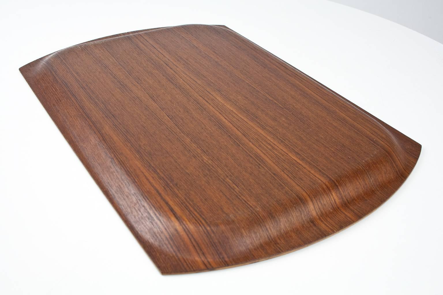 Scandinavian Modern serving tray in molded teak. Beautiful home accessory. The tray has a rectangle design with slightly curved edges and a raised lip. Unsigned. 

Condition: Excellent vintage condition; professionally cleaned and oiled.