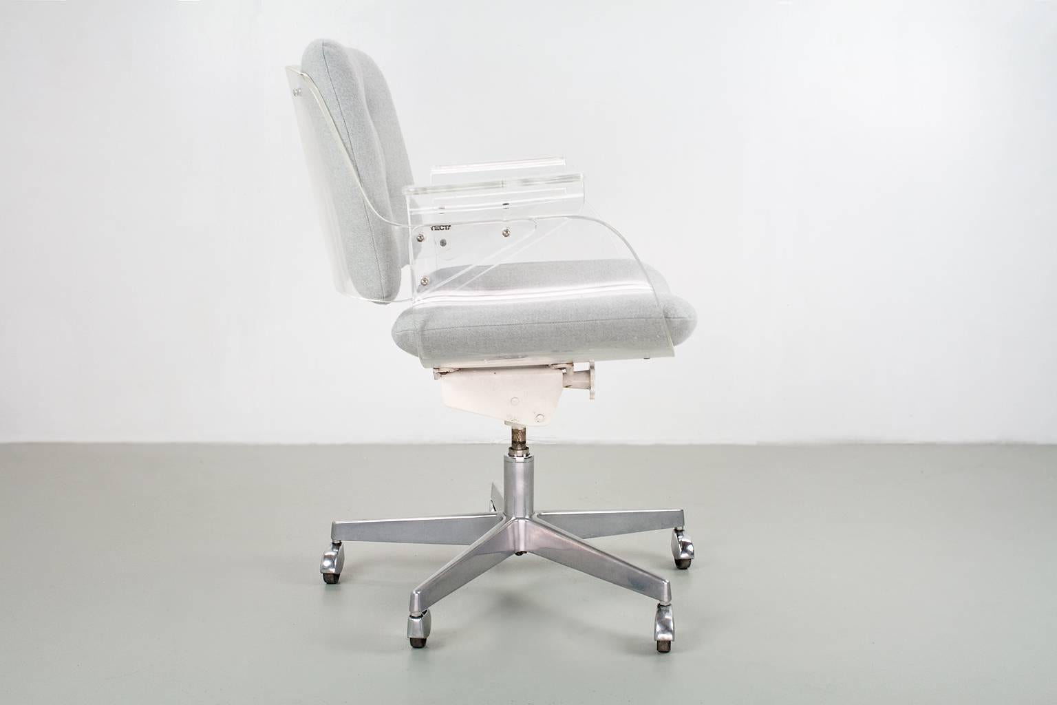 This lucite and metal desk swivel chair is an early edition design by Hans Konecke for Tecta, D49 model. The mechanisme and the vintage caps covering the wheels show an early origin, late 1950s. 
The item is re-upholstered in a very good quality