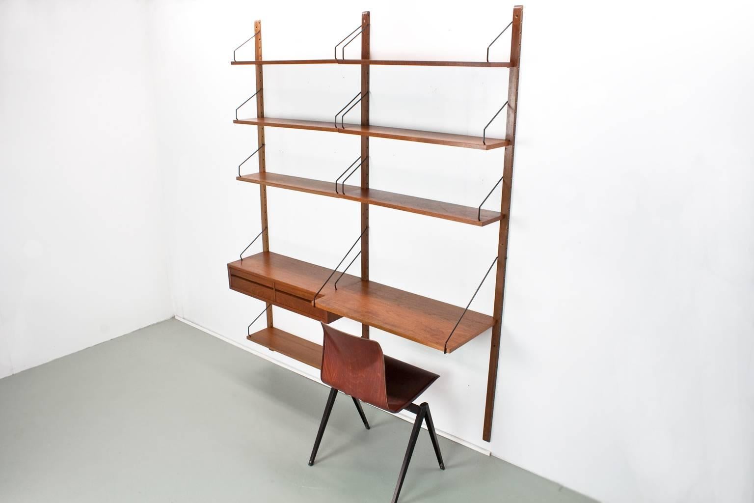 Original Danish wall unit, model Royal, designed by Poul Cadovius in the 1950s for Cado, Denmark. 

This listed unit was produced by Cado in Denmark in the 1960s. The elements features a lovely quality teak veneer with brown uprights of 2 meter.