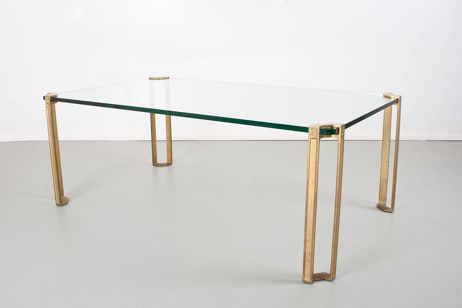 Peter Ghyczy glass and brass table, circa 1970. The table is made from glass (1.5cm thick) and sand casted brass. The legs are hand casted. The brass has typical characteristics of the casting process.

After the Hungarian revolution Peter Ghyczy