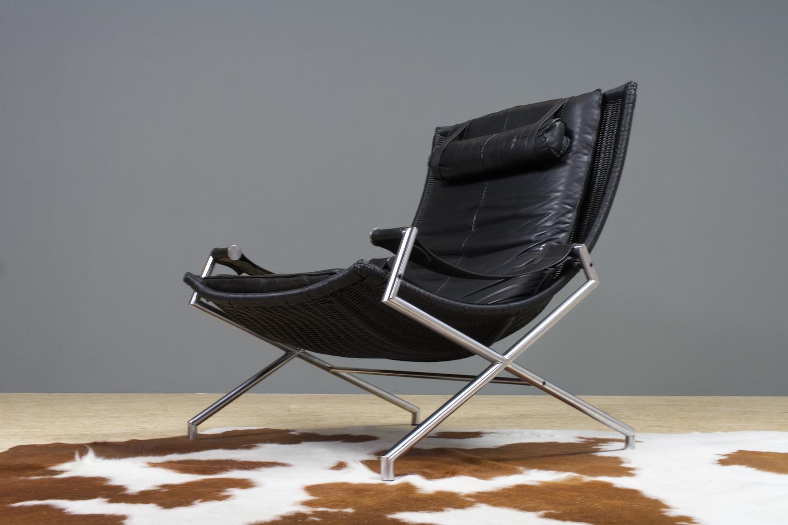 Although the base of this chair is sleek and transparent; the seating is present, large and well-shaped, and therefor very comfortable. Large and Brutalist modern Dutch lounge chair in chromed metal and black leather by Gerard Van Den Berg for Rohé