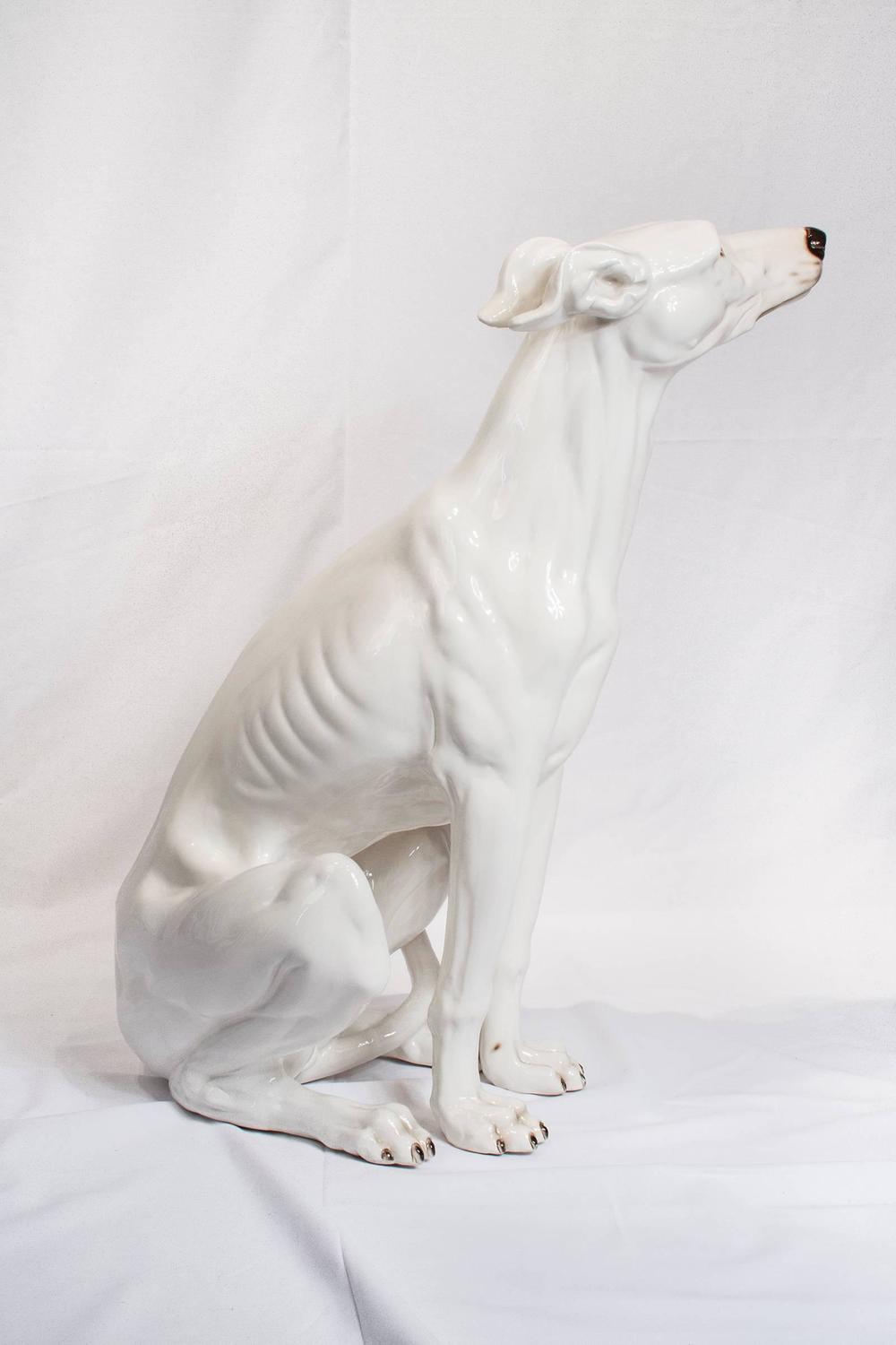 white ceramic greyhound statue
