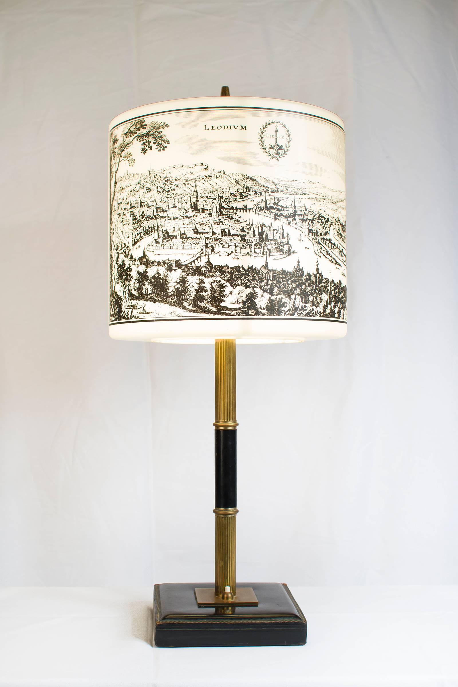 Table light with two historical pictures of Spa and Liège, 1970s. The cloche is painted opaline and the foot is a mix of leather and gold metal. This lamp is very decorative, the cloche is completely in the taste of Fornasetti and the foot is in