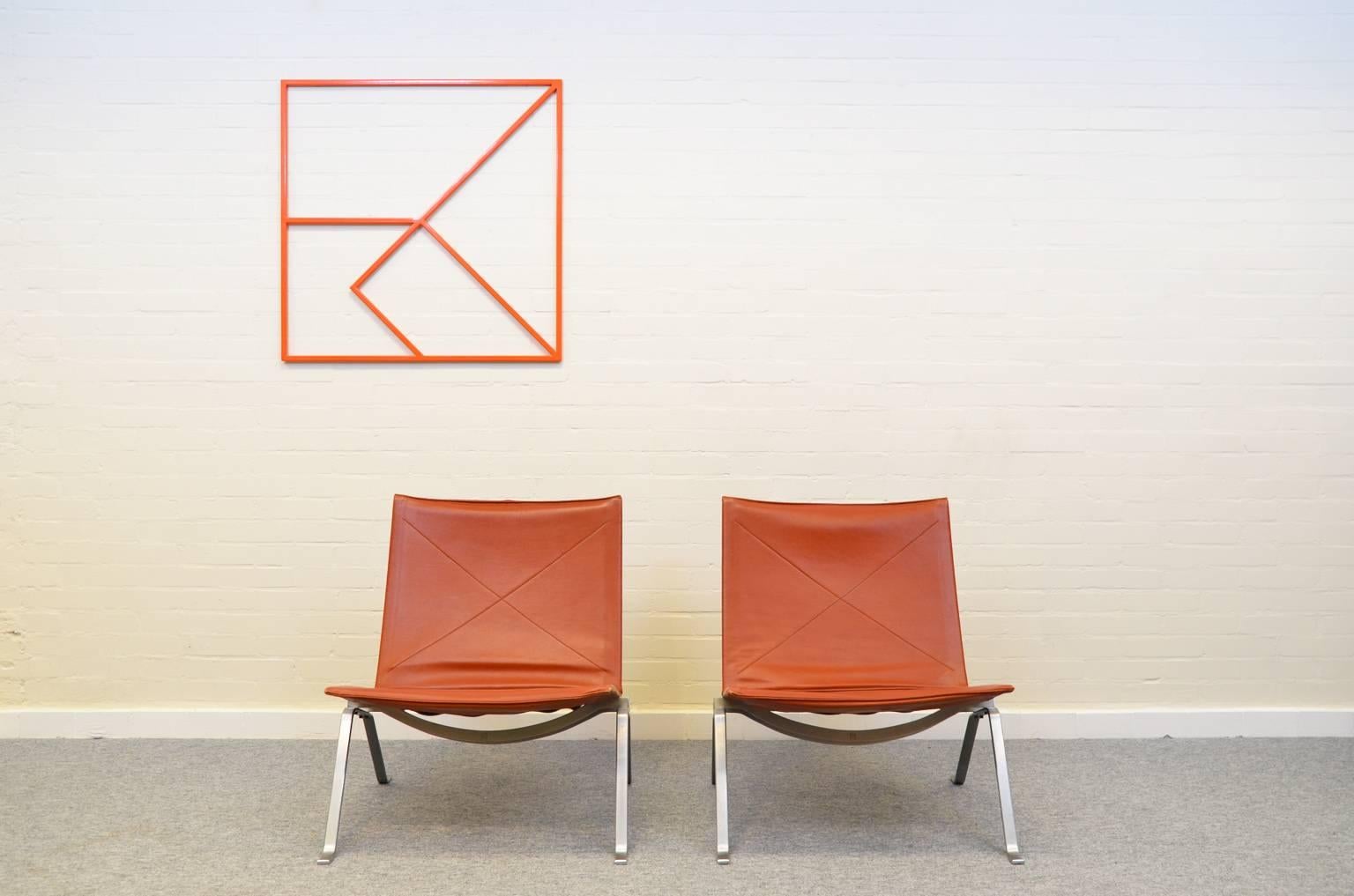 E. Kold Christensen logo in orange-colored metal designed by Poul Kjaerholm in 1956. Made of lacquered steel and in an excellent and original condition.
