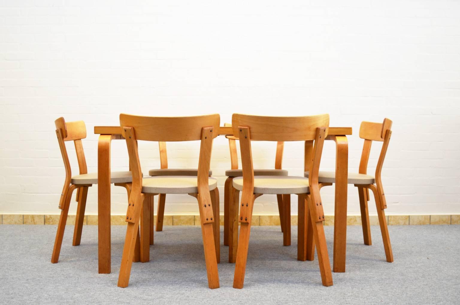 Iconic dining set from Finnish designer and architect Alvar Aalto. De set consists of a table (model 82A) and six chairs (model 69) with vinyl upholstery. All original from first owner.
Measurements table: Height 69 cm, width 121 cm, depth 75