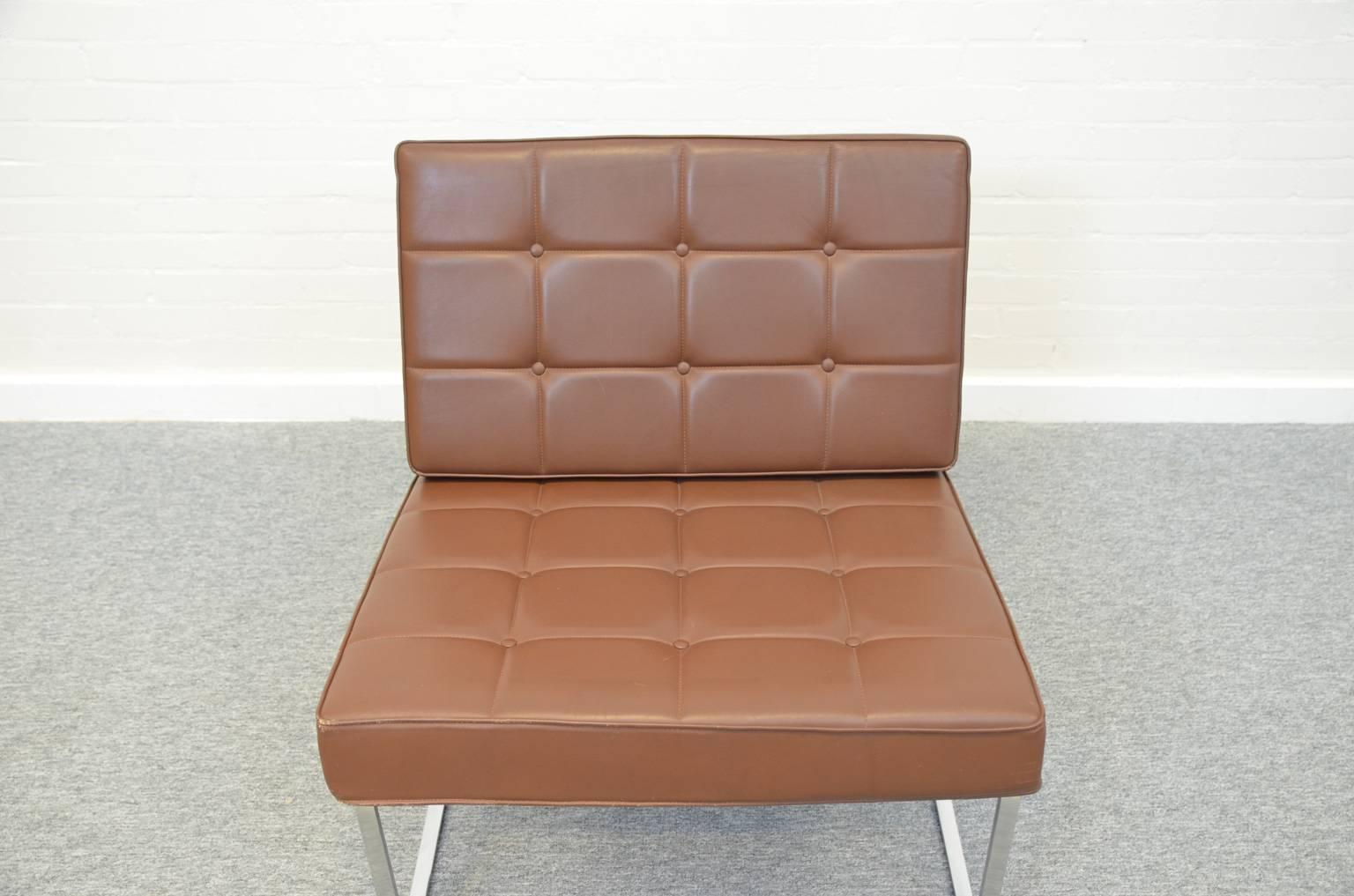 Lounge chair model 024 by Kho Liang Ie, made of metal, wood and (brown) artificial leather. Firm seating because of the use of wooden slats under the cushions. The chair is in a very good condition, with minimal user marks.