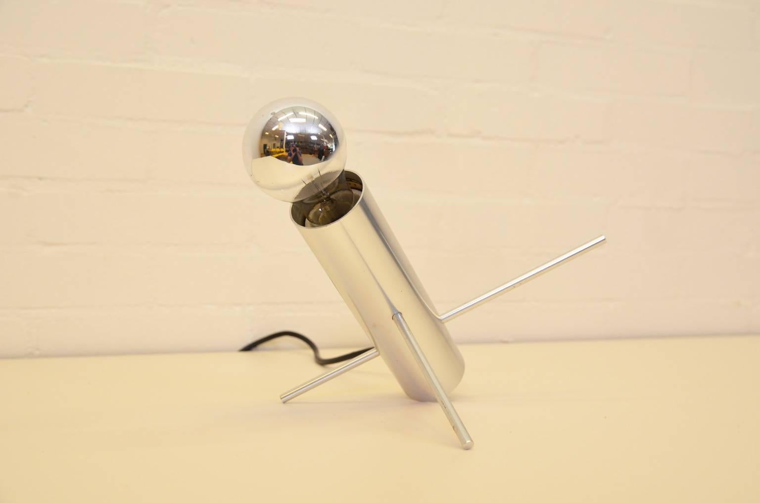Die Grillenlampe Modell R60 des Designers Otto Wach besteht aus einem polierten Metallrohr mit zwei Metallstiften. Durch Verstellen dieser Metallstifte kann die Lampe in verschiedene Positionen gebracht werden. Hergestellt von RAAK Amsterdam.