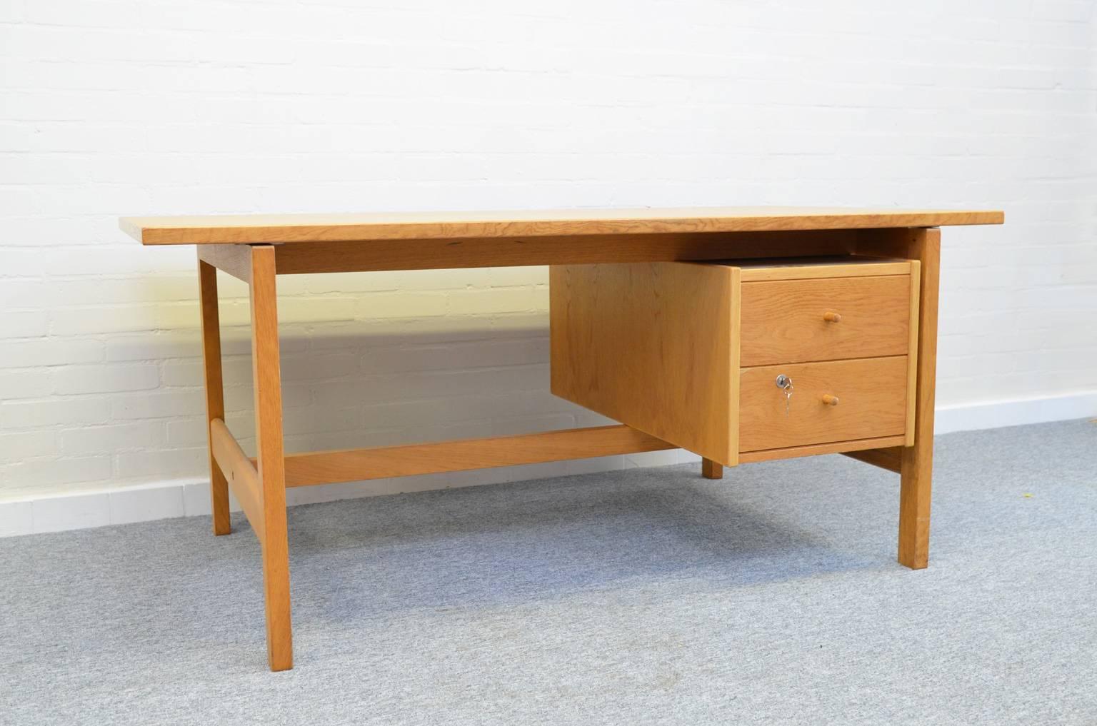 Straight forward design by Hans Wagner, made in solid oak. Originally designed for a Danish school, later on also sold for private use. It is worth mentioning that the desk can be used on both sides.