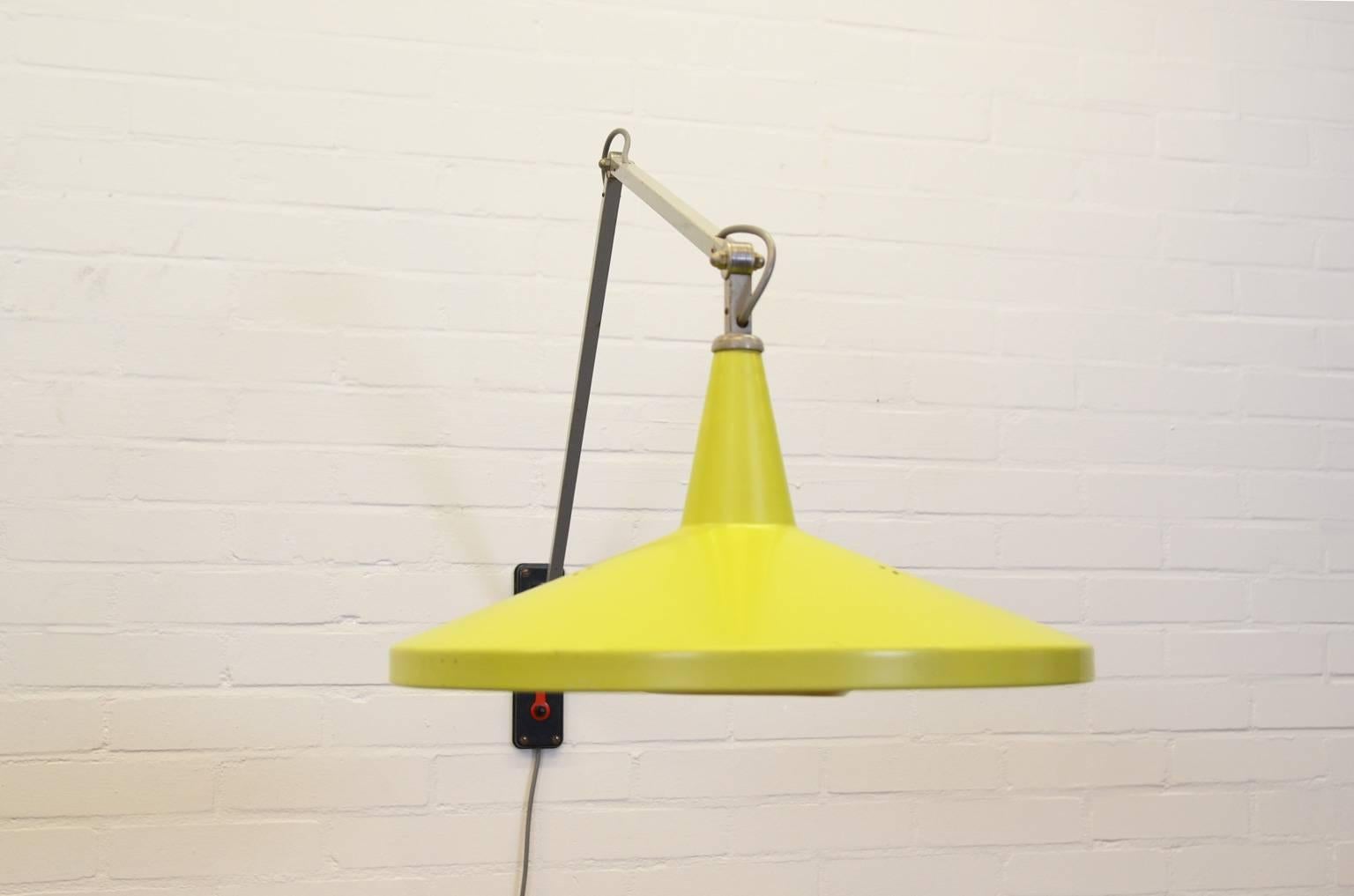 This wall lamp (model 4050) is one of the first items belonging to the Dutch Industrial Design movement and is designed by Wim Rietveld for Gispen. The lamp is adjustable in many positions due to three pivot points. The lamp spreads warm light by