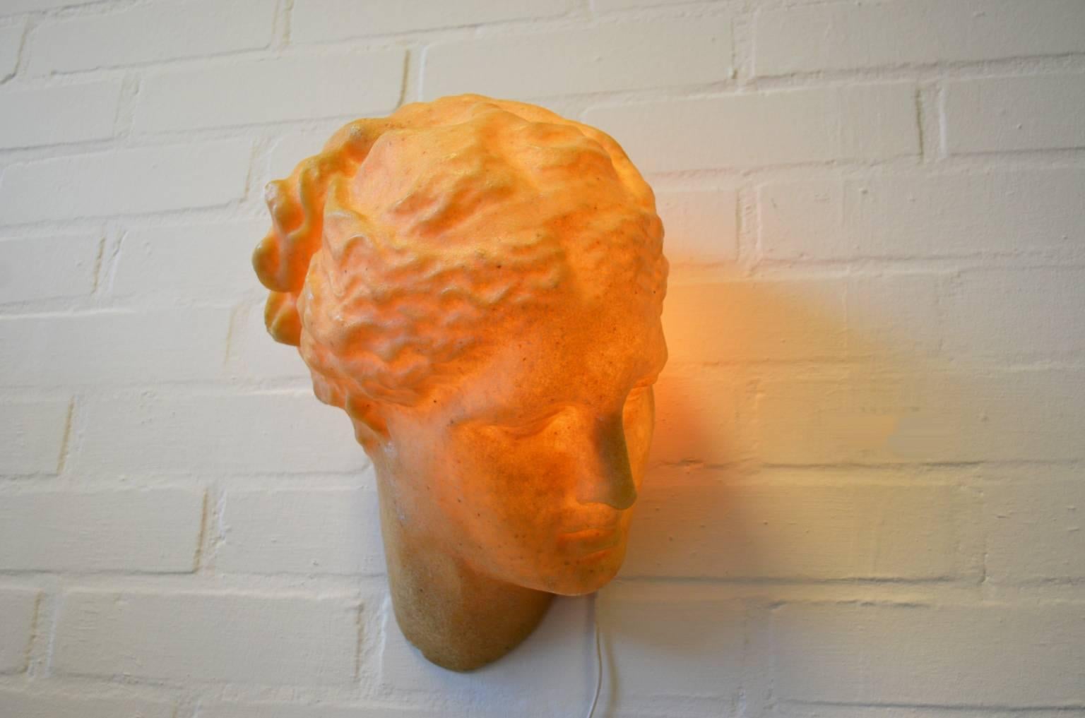 Wall lamp designed by André Cazenave for Atelier A France. The lamp looks like a sculpture depicting the Greek goddess Aphrodite. It is made of polyester and marble powder. The lamp is in a good condition with a small damage to the goddess her neck.