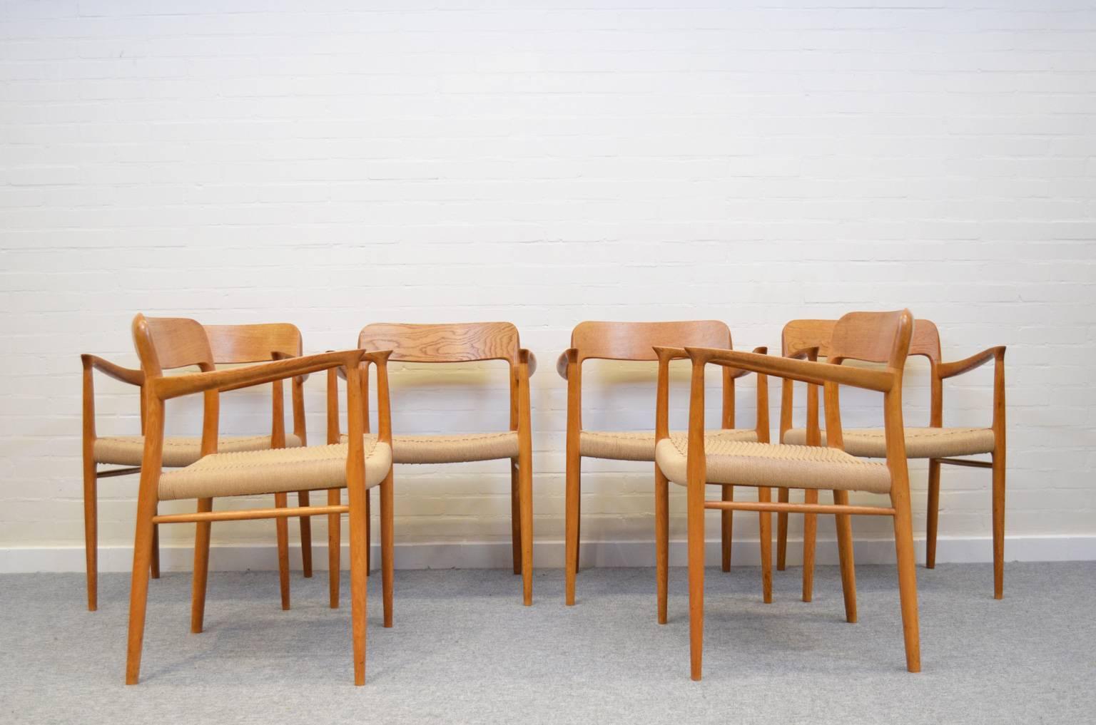 Midcentury set of six solid oak dining chairs, model 56, by Niels Otto Møller for J.L. Møller Møbelfabrik. All papercord seats have been renewed. The height of the armrests is 68 cm (or 26,75 inch). 