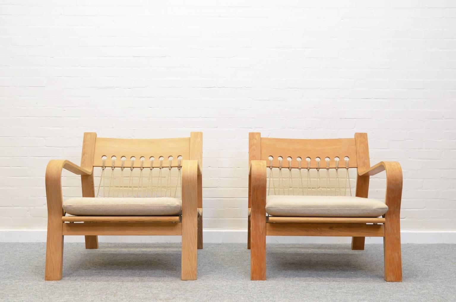 Hans Wegner GE-671 lounge chair, designed in 1967 and produced by GETAMA. Laminated oak with a flag line back, loose cushion upholstered in off-white wool. There is only one chair available, the chair on the right.