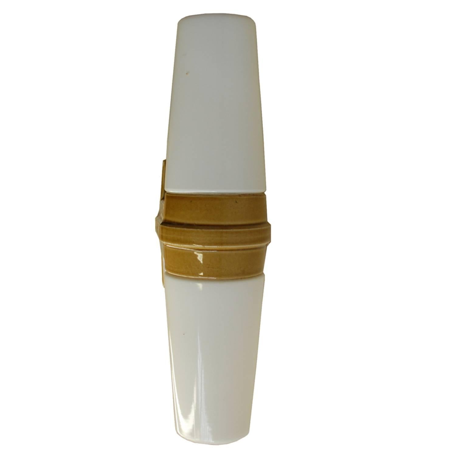 Beautiful yellowish ceramic wall sconce with opaline glass lampshades. It was made in the early 1960s by Ifö in Sweden and designed by Sigvard Bernadotte. The lamp is in a perfect working condition.