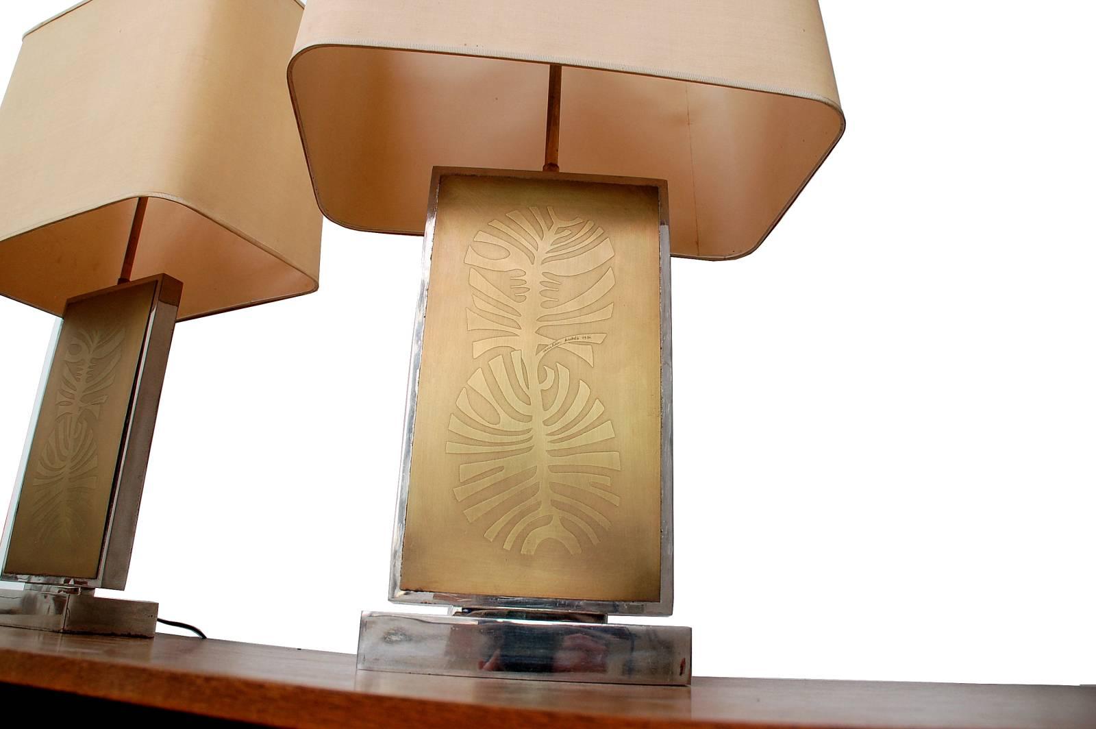 Amazing set of two monumental table lamps in chromed metal and brass. A stunning drawing of a leaf is etched into the front. The design of these lamps is by the Belgian artist Christian Krekels who signed them in 1976. The original lampshades are