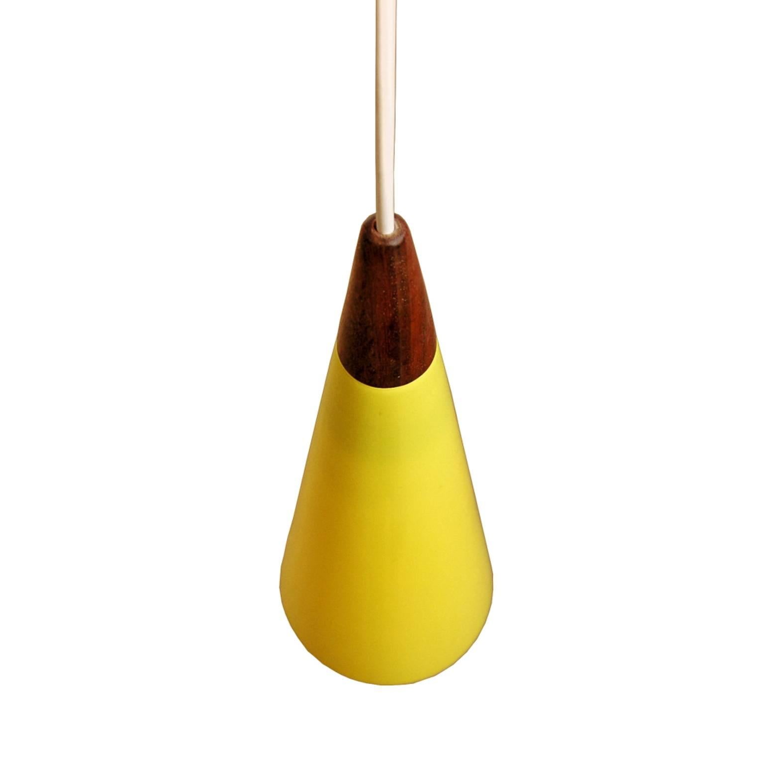 Beautiful set of bright yellow pendant lamps. Released by Fog and Morup in the early 1960s under the name 'trompet.' The opaline glass lampshade is by the famous Holmegaard glass company. The small peace of elegantly shaped teak completes the design