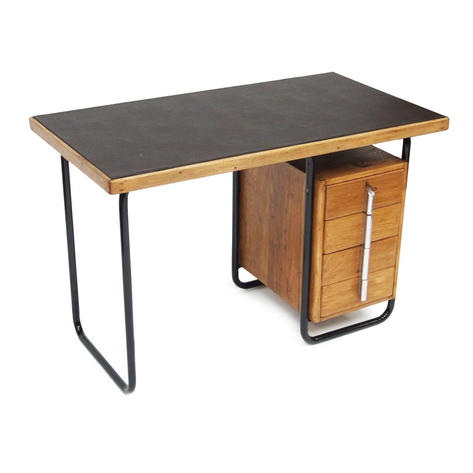 1930s modernist desk designed by Wells Coates for Kingfisher, UK.

Black tubular steel frame with oak drawer unit. Brown leatherette worktop.

Four matching drawers with chrome handles. Lockable top drawer with key.
Kingfisher