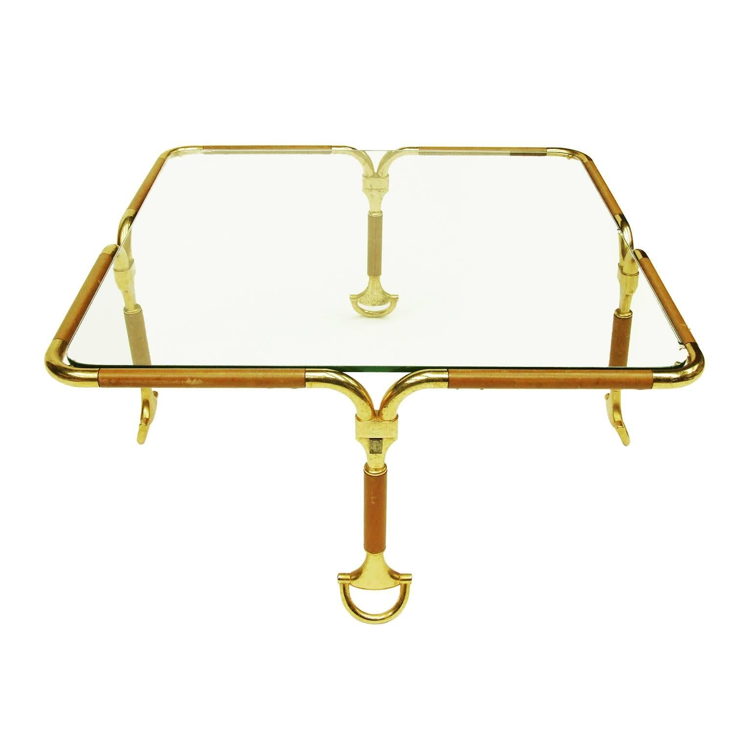 1970s rare occasional table designed by Gucci, Italy.

Gold-plated tubular metal frame with tan leather detail. Four stirrup feet.

Clear glass insert.

