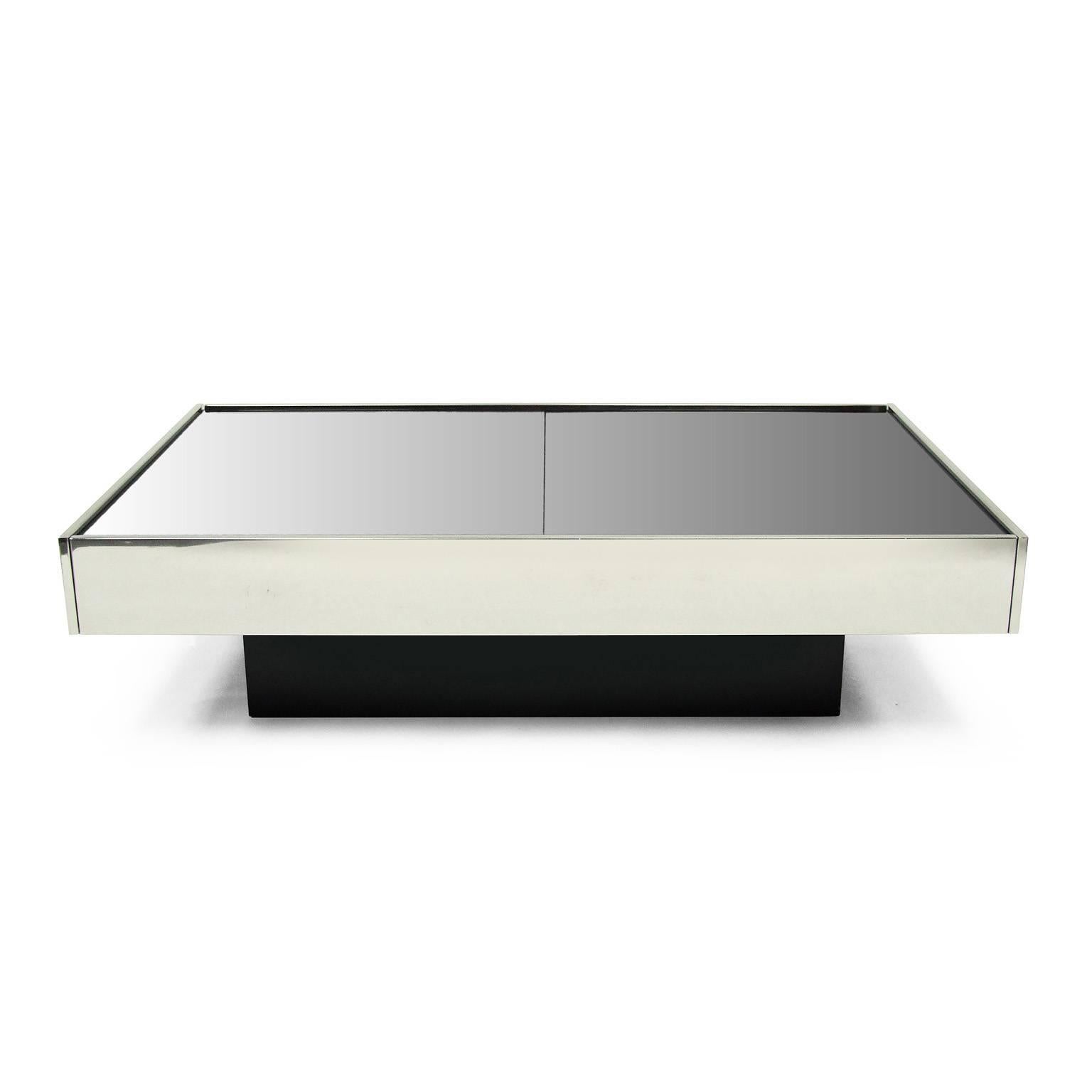 1970s cocktail table designed by Willy Rizzo for Cidue, Italy.

Polished aluminium with two tinted mirror sliding surfaces. Internal storage finished in mirror. Perspex bottle holder.

Black laminate plinth.

This table is a stunning example in