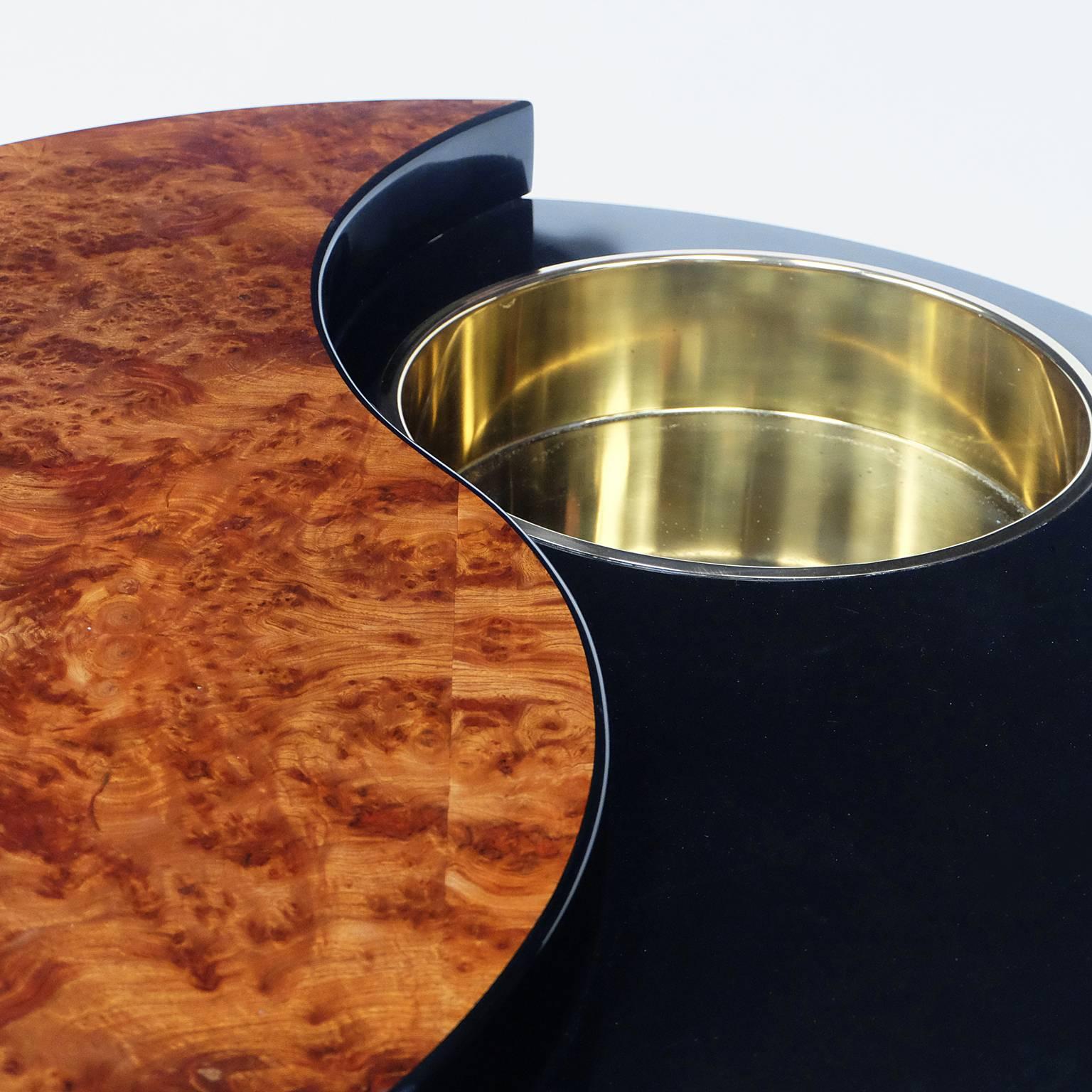 1970s rotating coffee table designed by Willy Rizzo, Italy.

Black lacquered unit with burr walnut inlay. Fixed brass circular insert.

Black laminate plinth.

Measures: H 39cm x L 107cm x W 107cm.