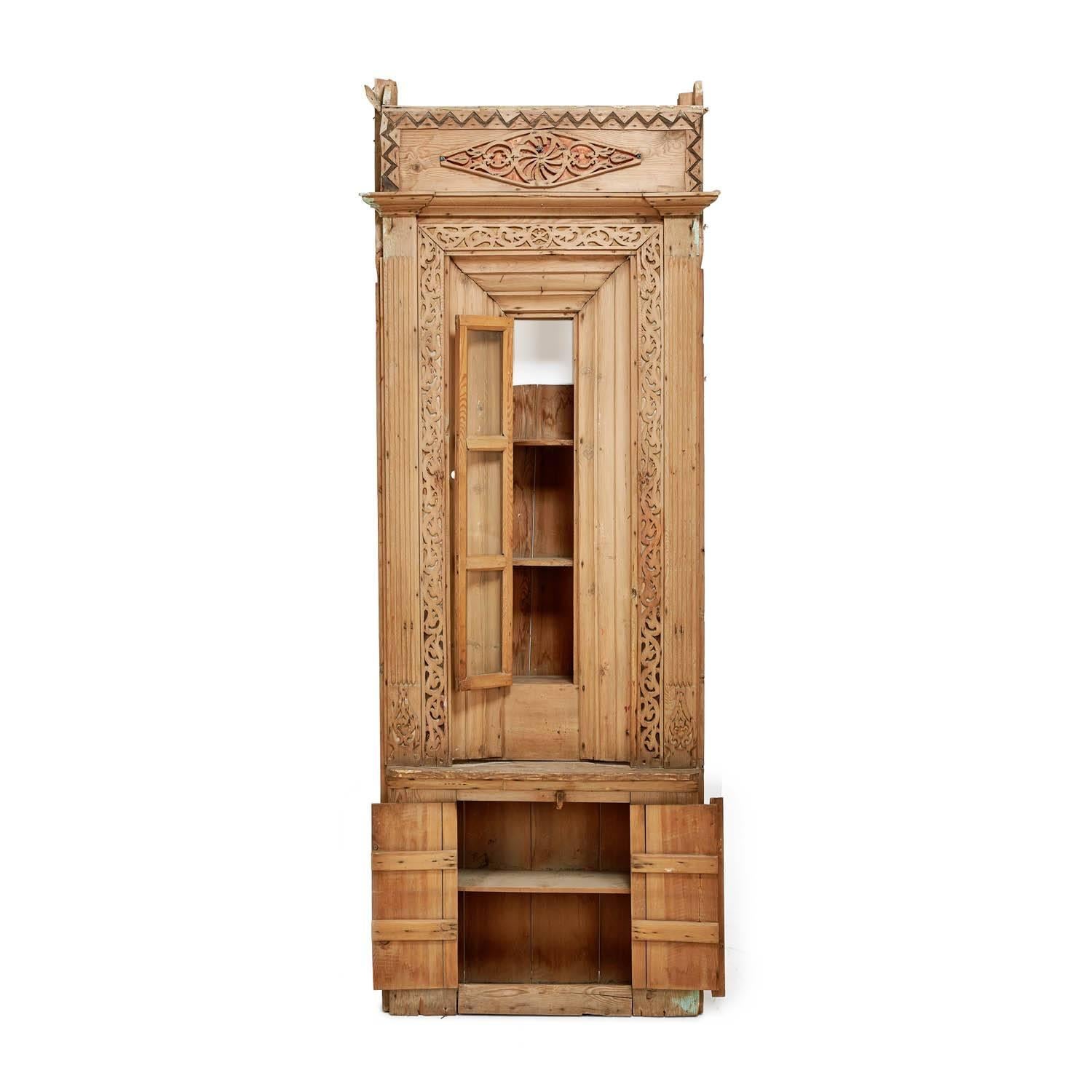 This Turkish cabinet has a meticulously carved lattice design which reflects the intricate wood carvings for which the Anatolian city of Konya is known. Set deep within its intricate border, a slender glass door opens to reveal three small shelves,