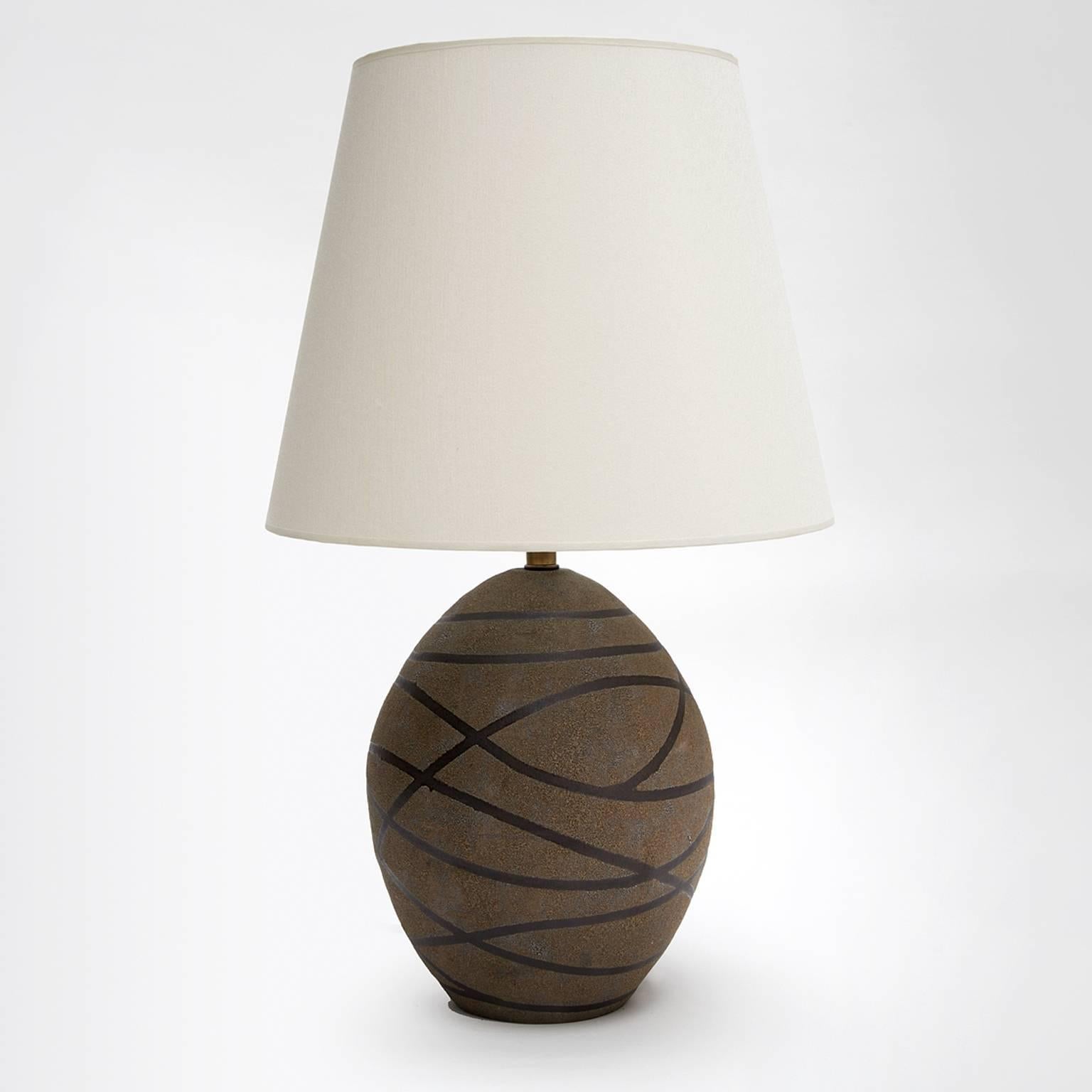 Black stripes ceramic glazed matte texture oval table lamp.
Unique.
Ceramic.
Industrial hand built.
Made in New York city.
Available at trans-LUXE.
Measurements: OAH 2'-0" F.
Table Lamp Base: 12" H x 9" W. 
Depth 16"