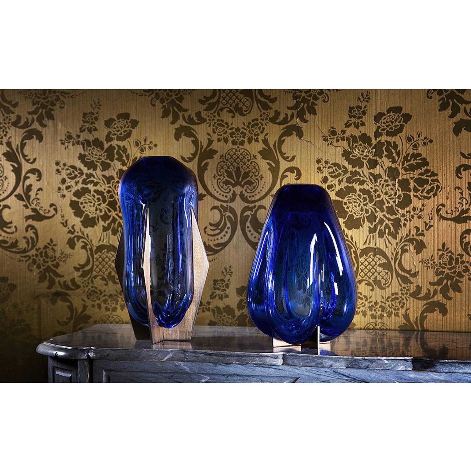 Lara Bohinc’s collection is inspired by her encounters with Venice . Metal frames hold Bohinc’s Murano glass vases and are reminiscent of the foundations upon which Venice was built: the metal is strong, rigid and geometric; the glass like water,