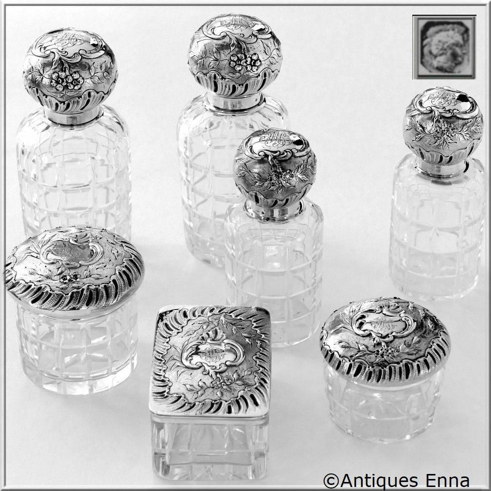 Head of Minerve 1st titre for 950/1000 French sterling silver. The quality of the gold used to recover sterling silver is a minimum of 750 mils (18-karat). 

Rococo decoration for this exceptional and rare dresser set seven pieces in sterling