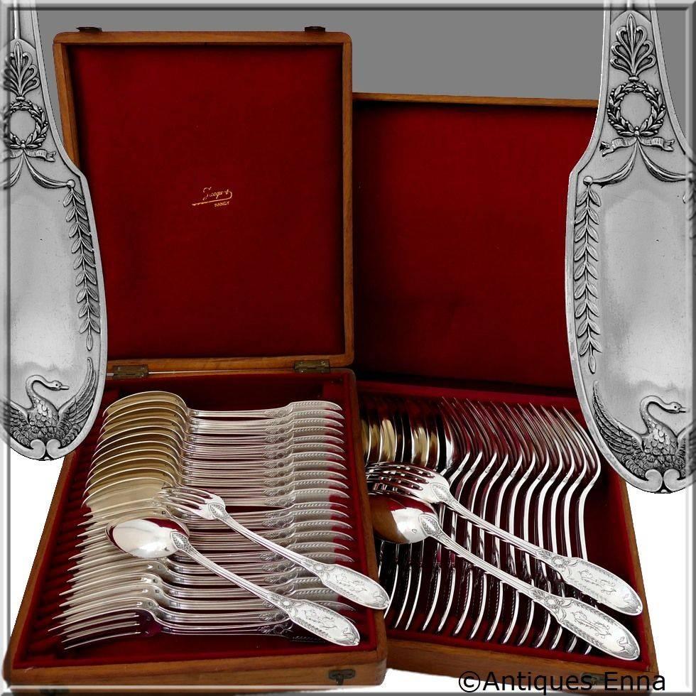 Head of Minerve 1st titre for 950/1000 French sterling silver guarantee. 

Exceptional French sterling silver flatware set 48 pieces Empire style with carved spatulas on both sides of Swan with outspread wings. Beautiful palmette decoration and