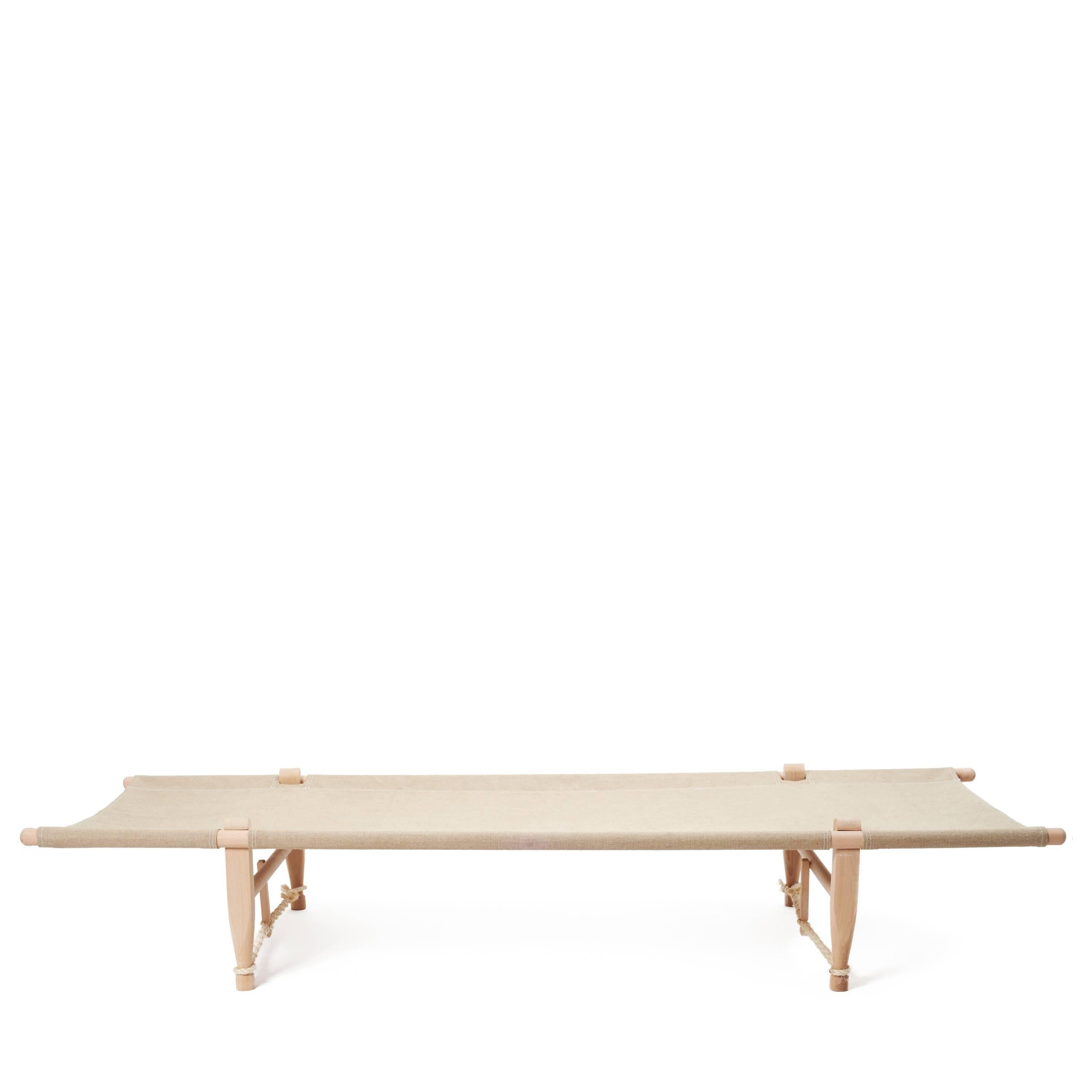 Designed in 1962 by Ole Gjerløv-Knudsen, this OGK natural safari daybed is portable, light, comfortable, and fully functions as a coffee table by day and a place of rest at night. Made of untreated beech wood, uncolored, natural linen cover and
