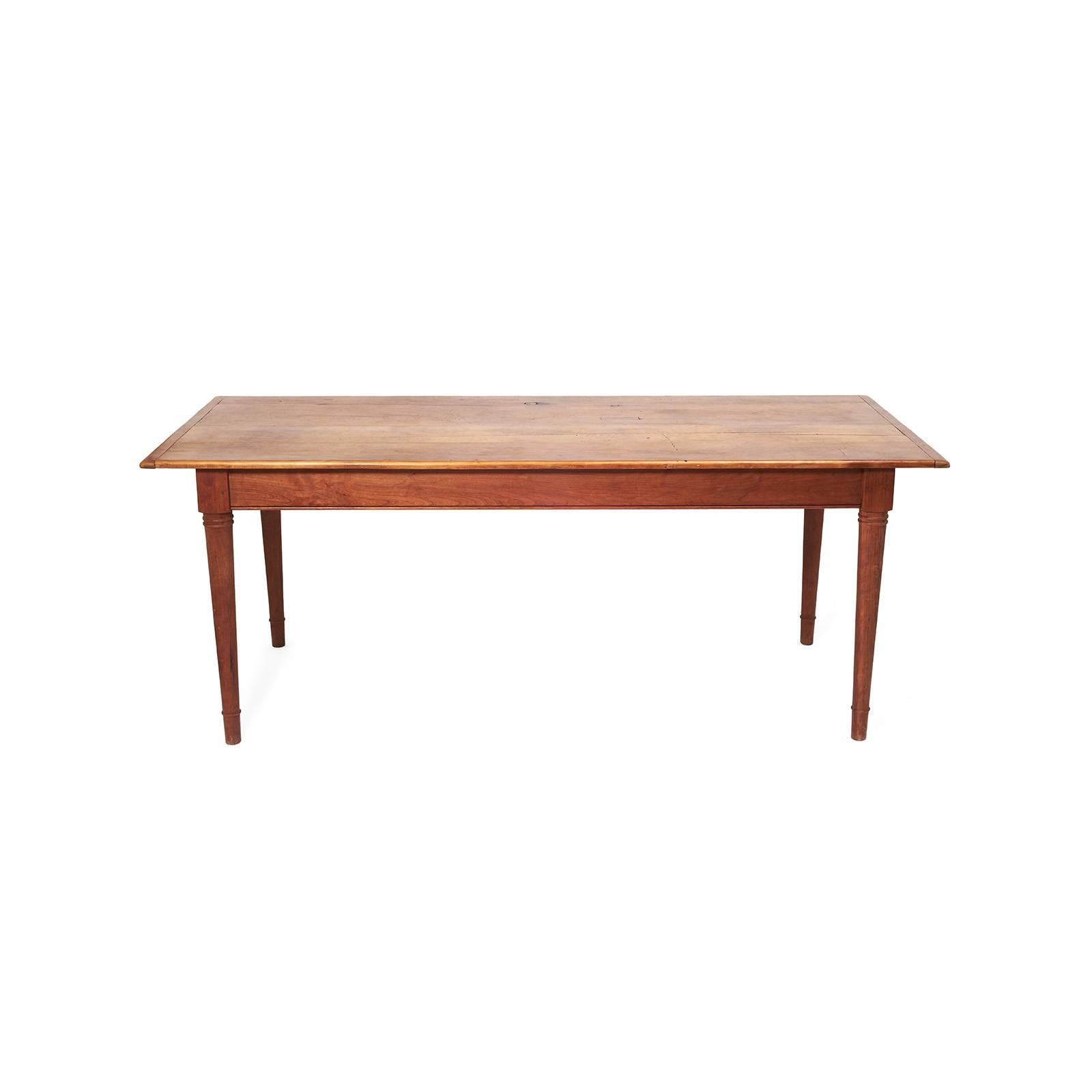 Solid wood 19th century farm table with handsome tapered legs. Great scale for dining, office or entry use. Height from the floor to the bottom of the apron is 24.75