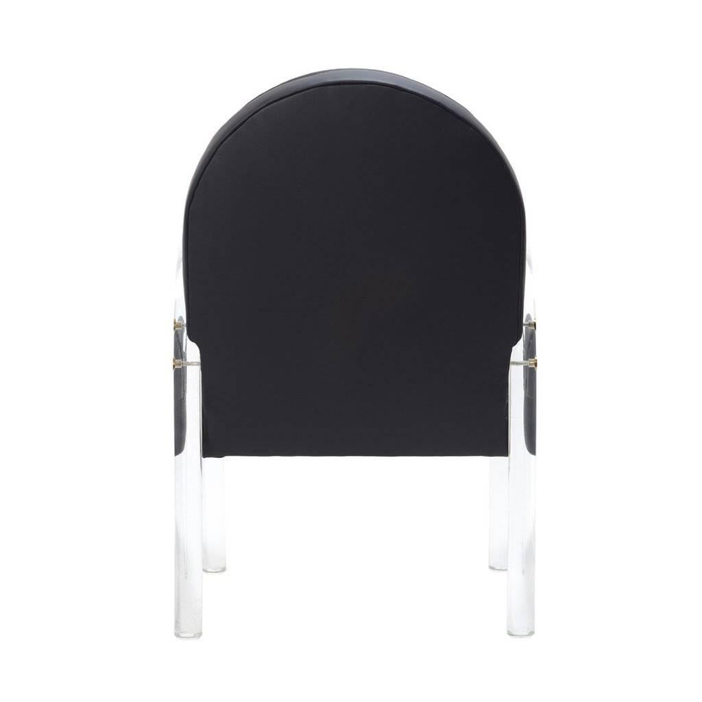 A playful accent chair with Lucite arms that has been newly upholstered in black leather. Brass detailing.