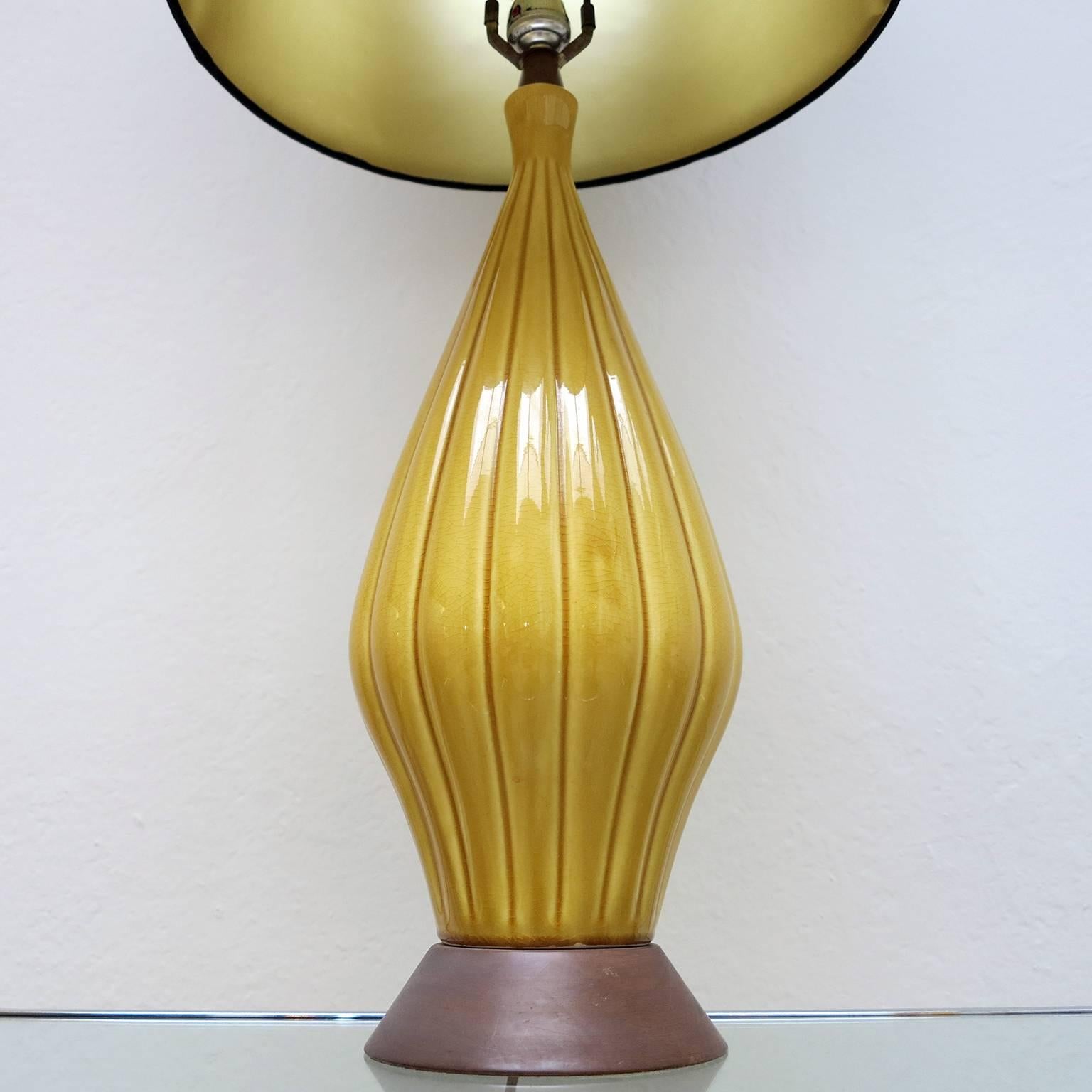 Beautiful table lamp manufactured in yellow colored porcelain with a wood base.