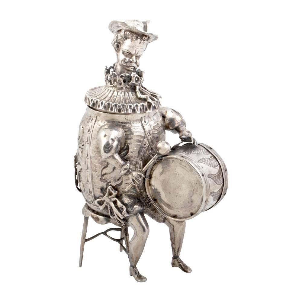 Two novelty, antique sterling silver seated musicians with bobble heads. Made by Ludwig Neresheimer in Hanau, late 19th century. The Drummer 7.5