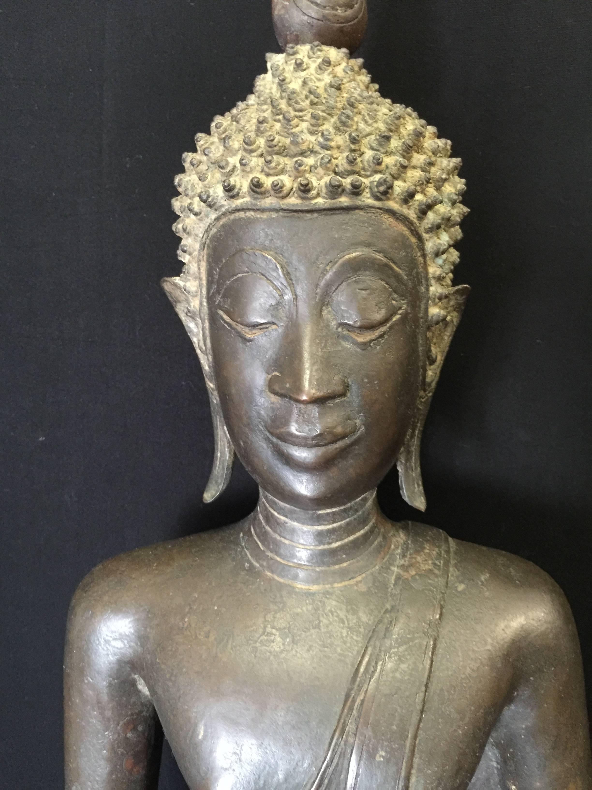 Large and beautiful sitting bronze Buddha from Laos. This rare Buddha is sitting on a large throne in a 